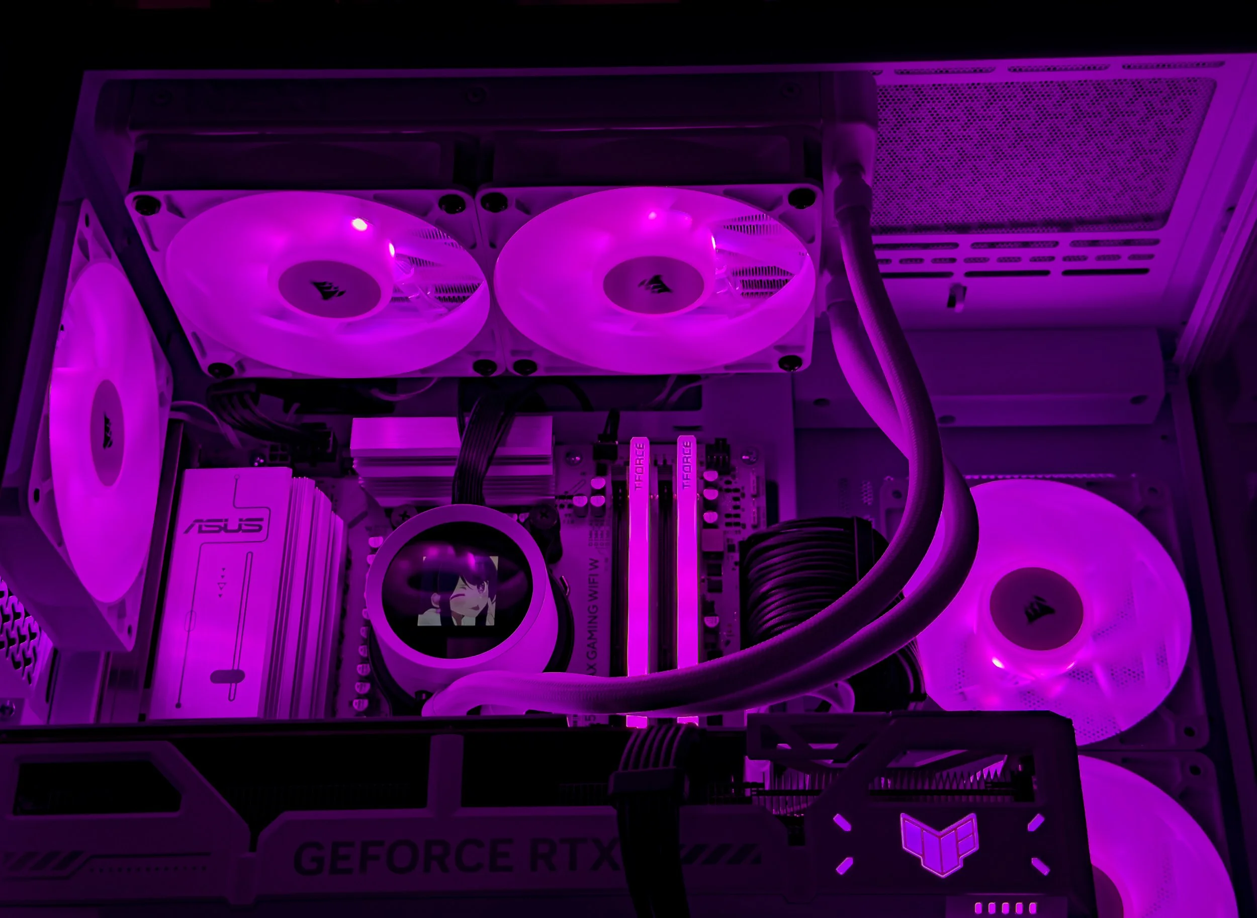 A computer graphics card with two cooling fans illuminated in purple, mounted inside a computer case with visible cables and components.