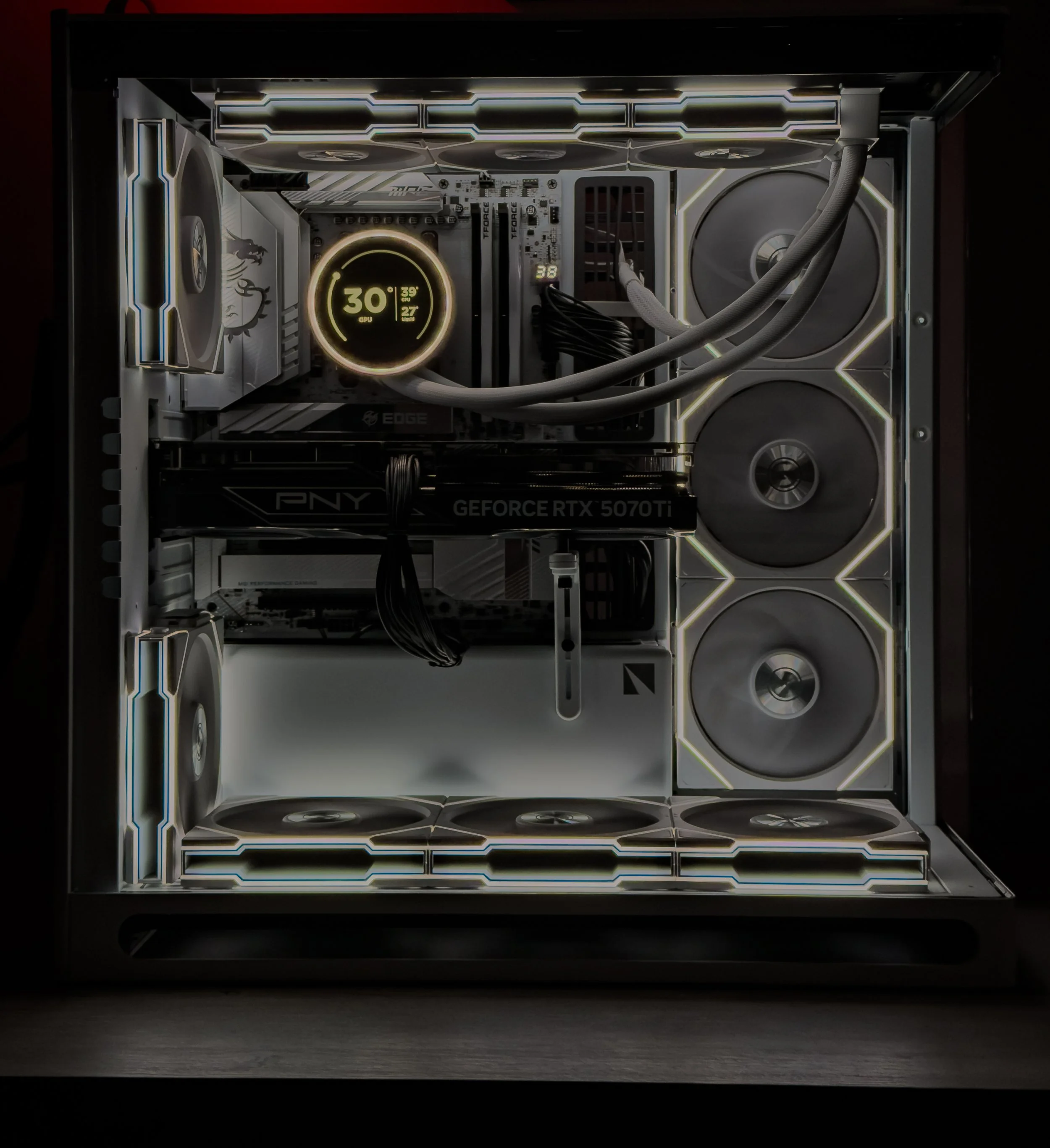 Inside view of a custom-built gaming computer with illuminated cooling fans, a digital temperature display, and a high-performance graphics card.