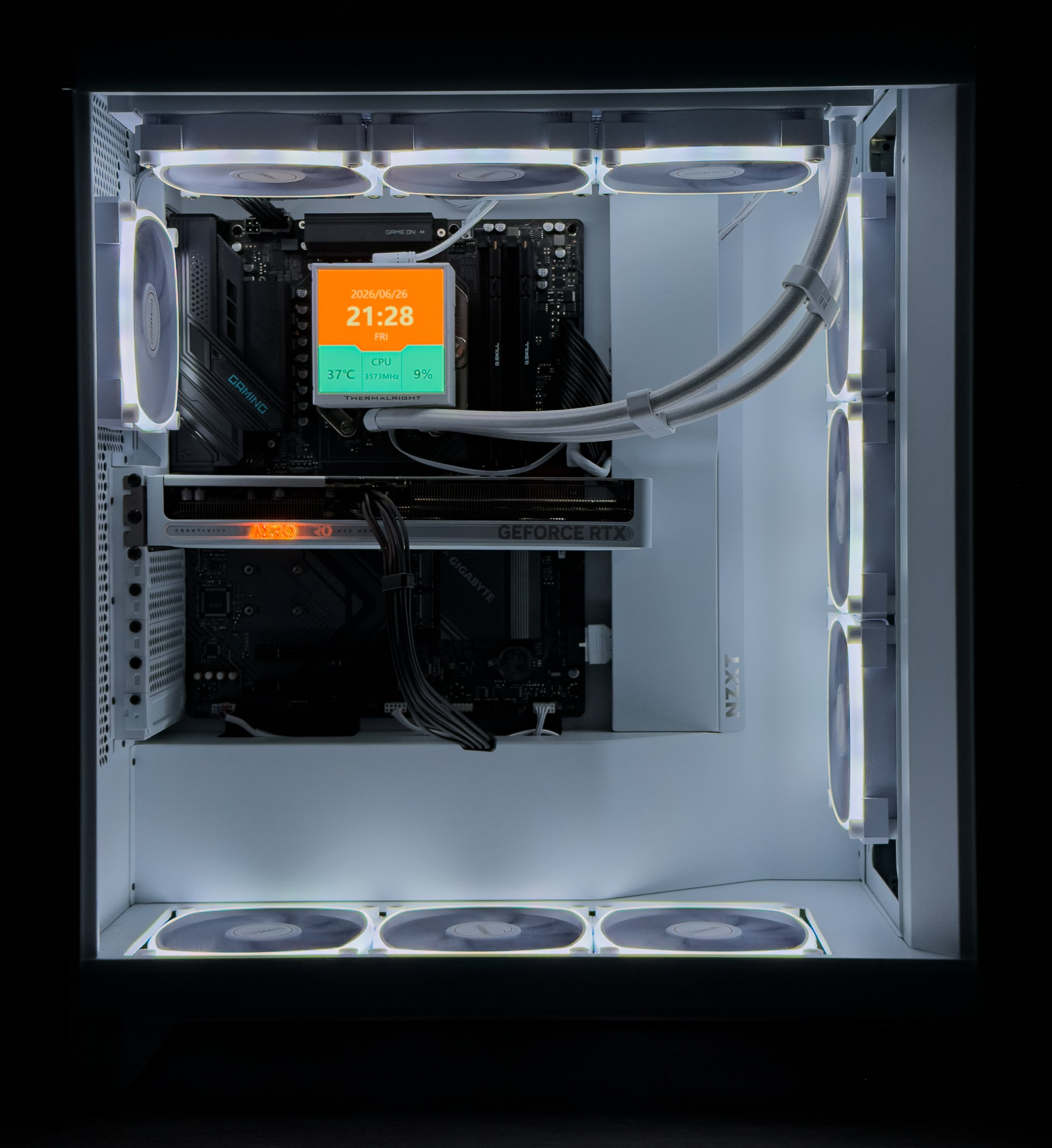 A custom-built computer case with white interior, featuring six cooling fans with white frames and black centers, an ASUS ROG graphics card, and a motherboard with a digital display showing date, time, temperature, CPU speed, and usage.
