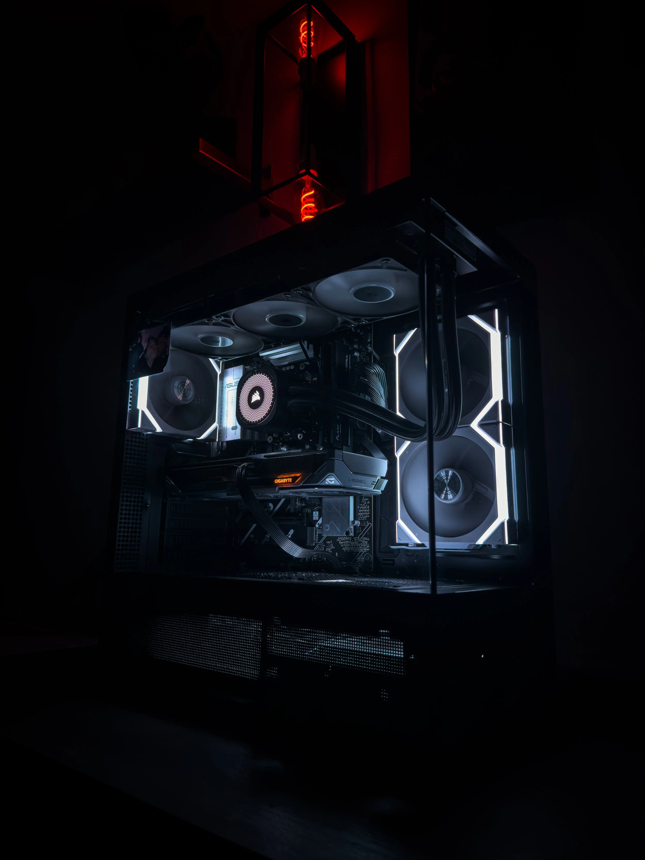 A custom-built gaming computer with white LED lighting, cooling fans, CPU and GPU components, and a dark background.