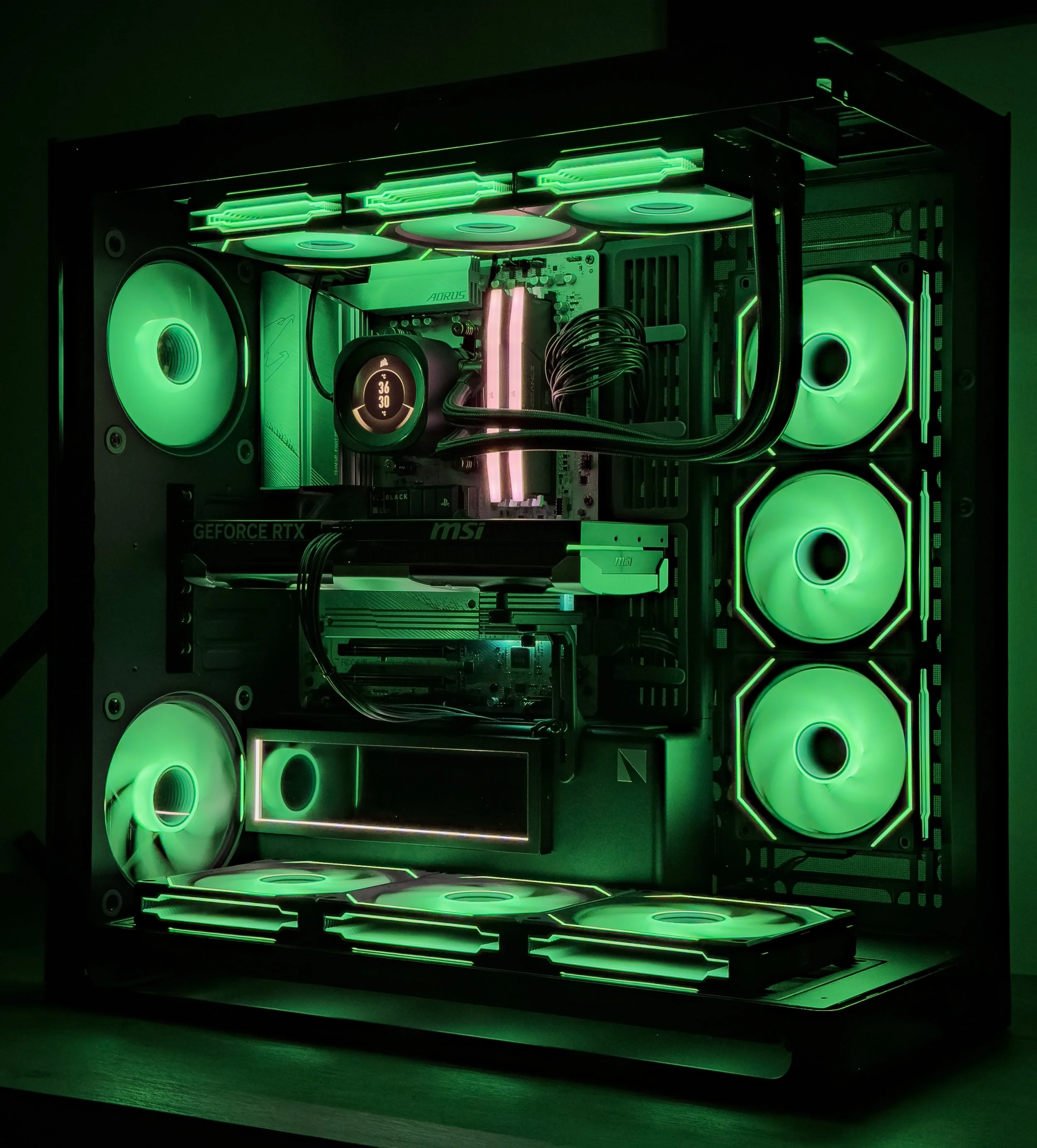 Gaming computer with illuminated green cooling fans, motherboard, graphics card, and LED lighting inside a black case.