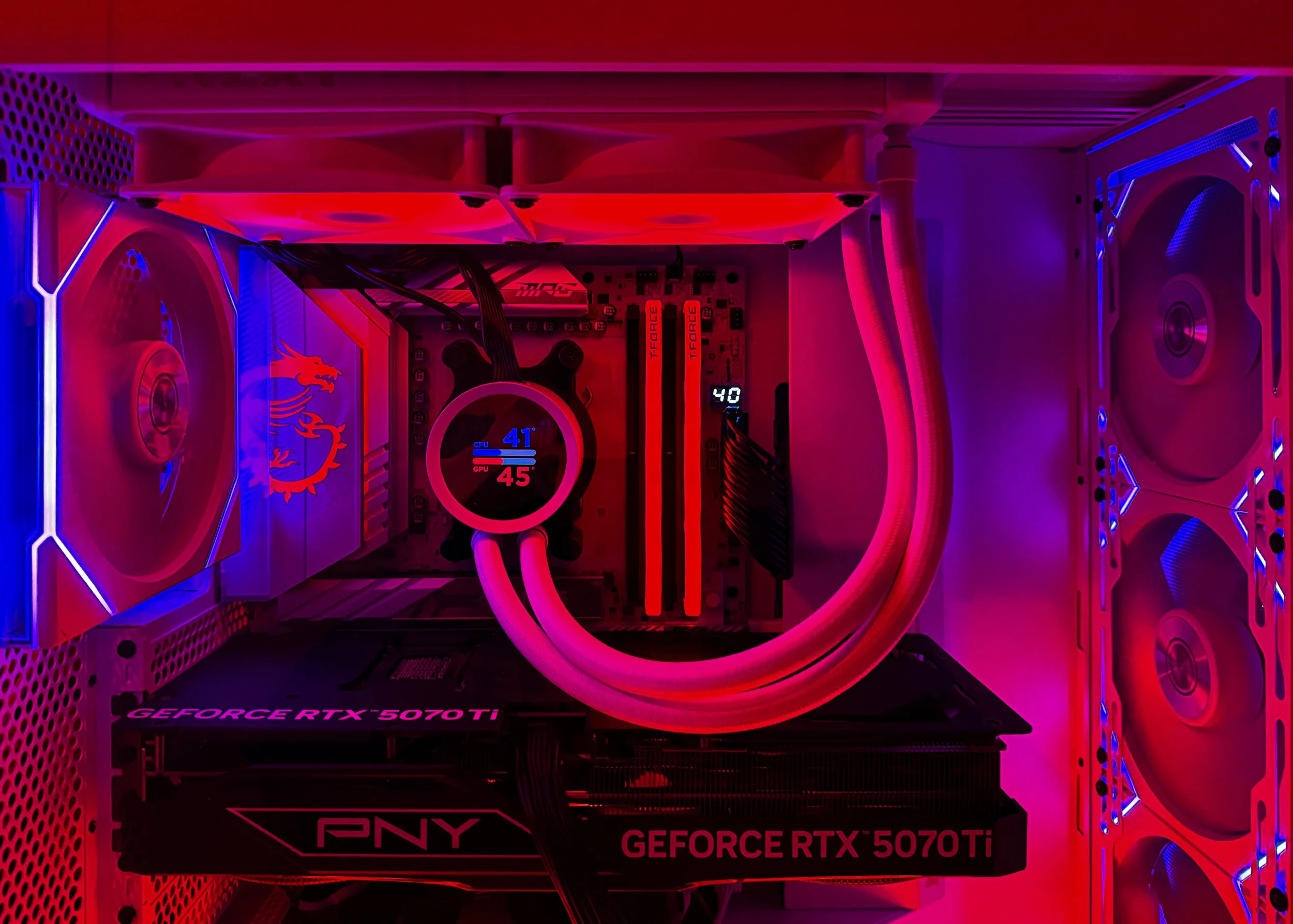 A computer graphics card inside a custom gaming PC with red and purple LED lighting. The graphics card is a PNY GeForce RTX 5070 Ti model.