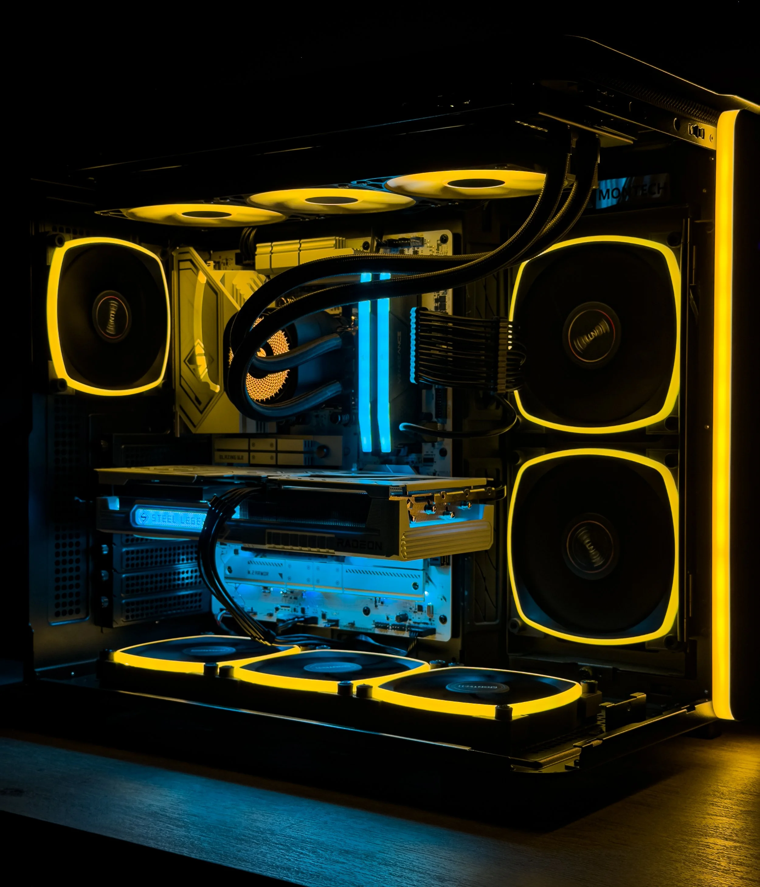 High-performance custom-built gaming computer with yellow LED lighting, cooling fans, and internal components visible inside a black case.