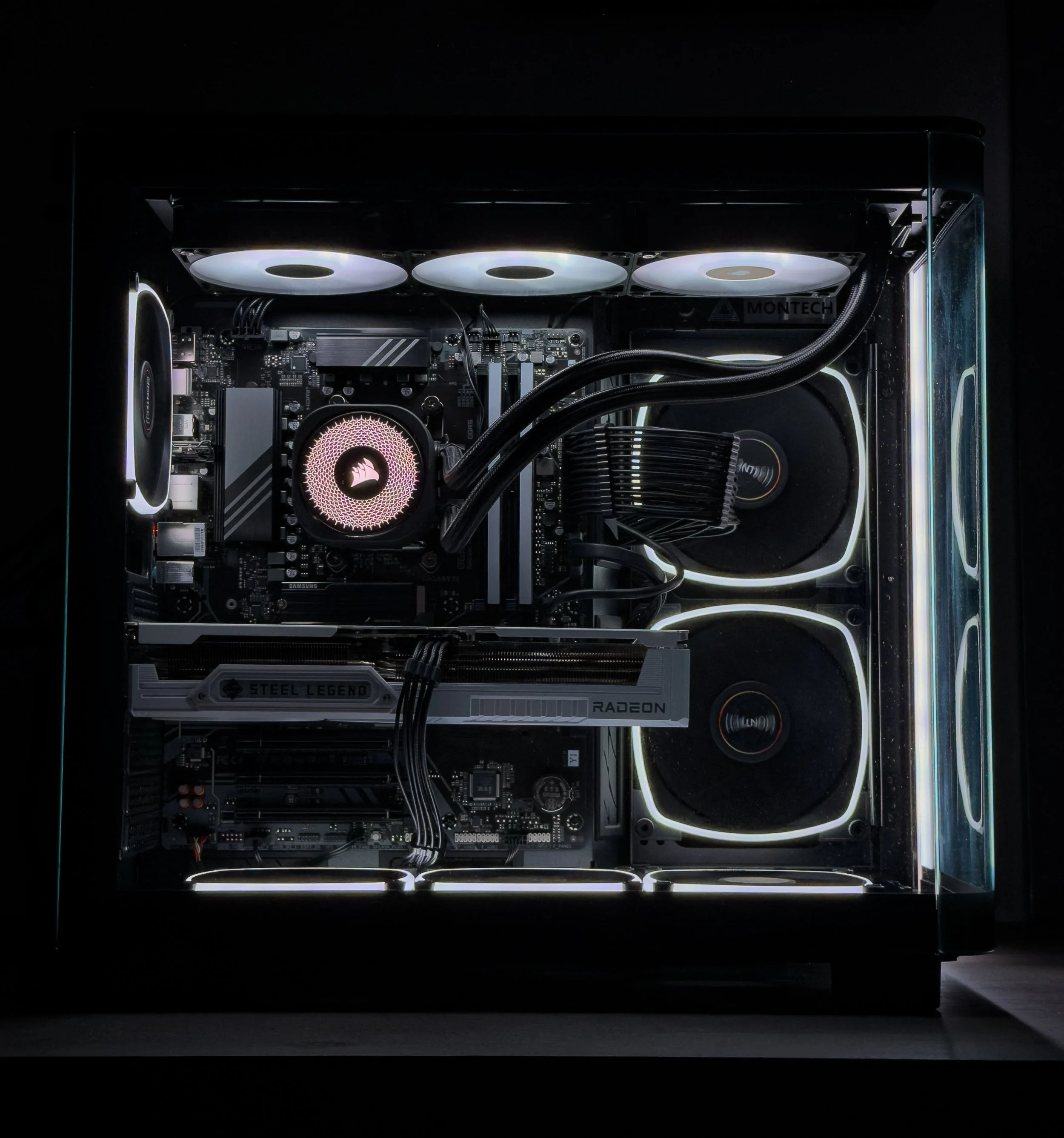 Close-up of a computer internal components with illuminated cooling fans and a transparent side panel, showcasing a modern gaming or high-performance desktop PC build.