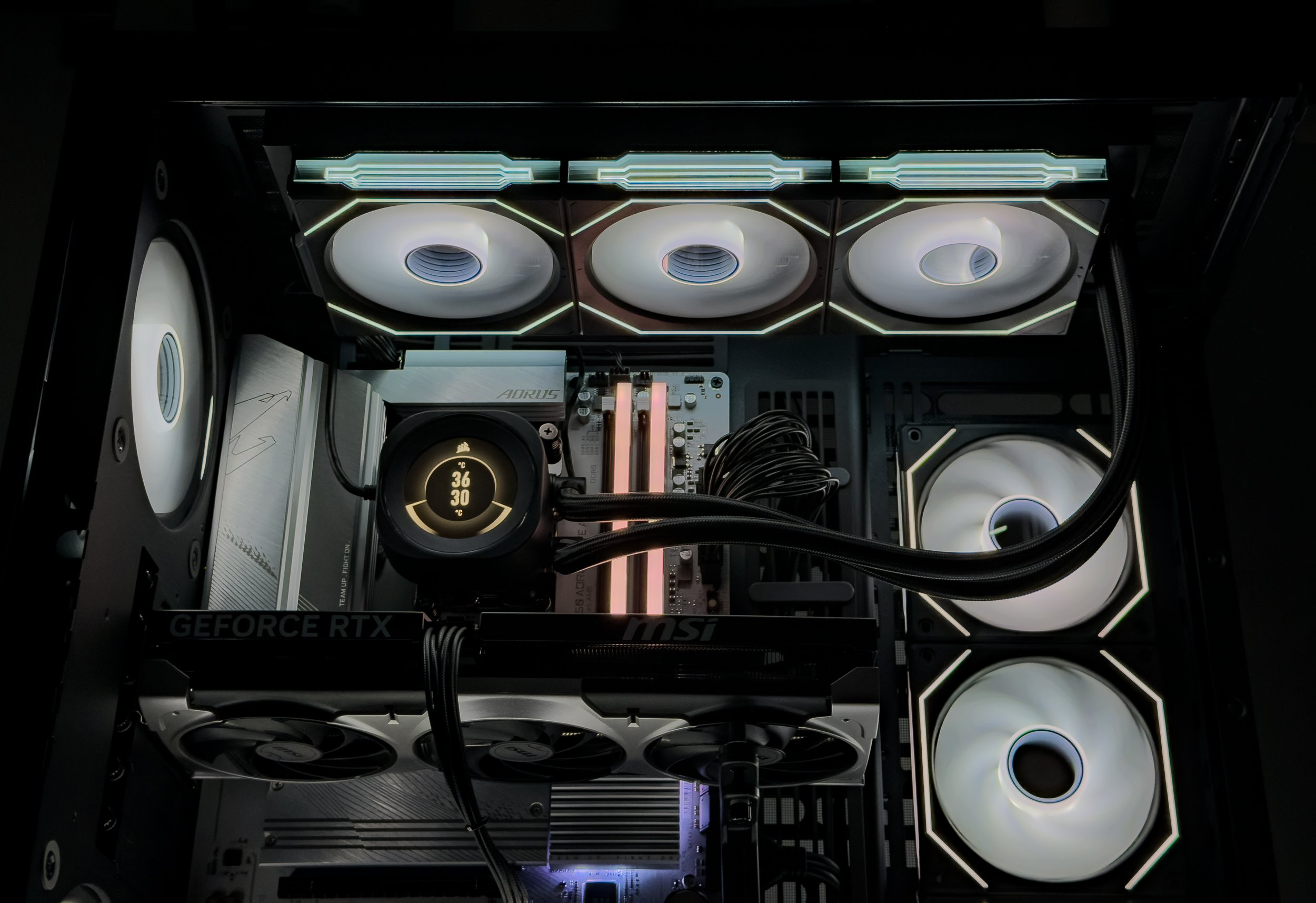 Inside view of a high-end gaming computer with multiple cooling fans, LED lighting, a CPU liquid cooler, and a GeForce RTX graphics card.