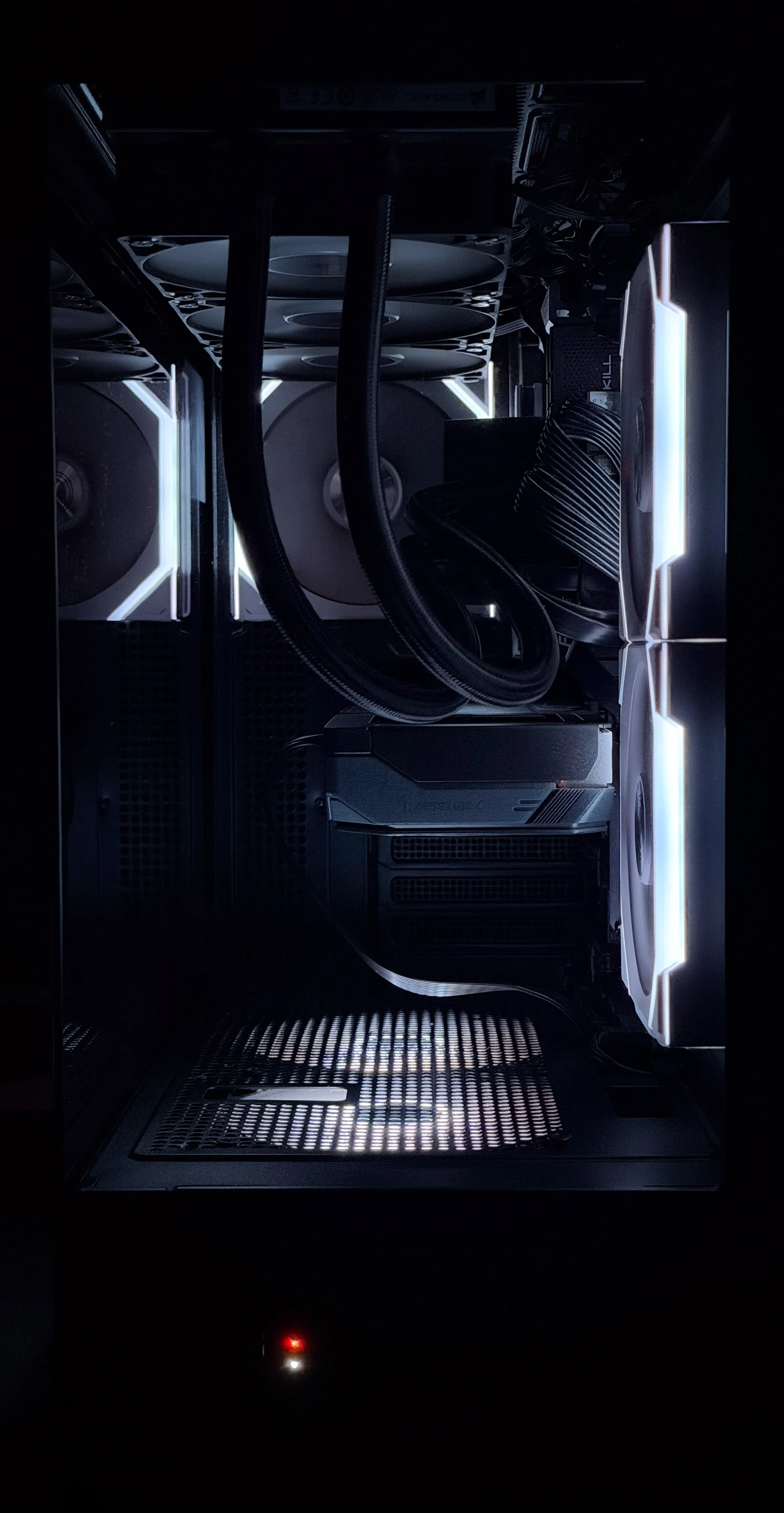 Inside a gaming or high-performance computer case with cooling fans, liquid cooling tubes, and illuminated components.