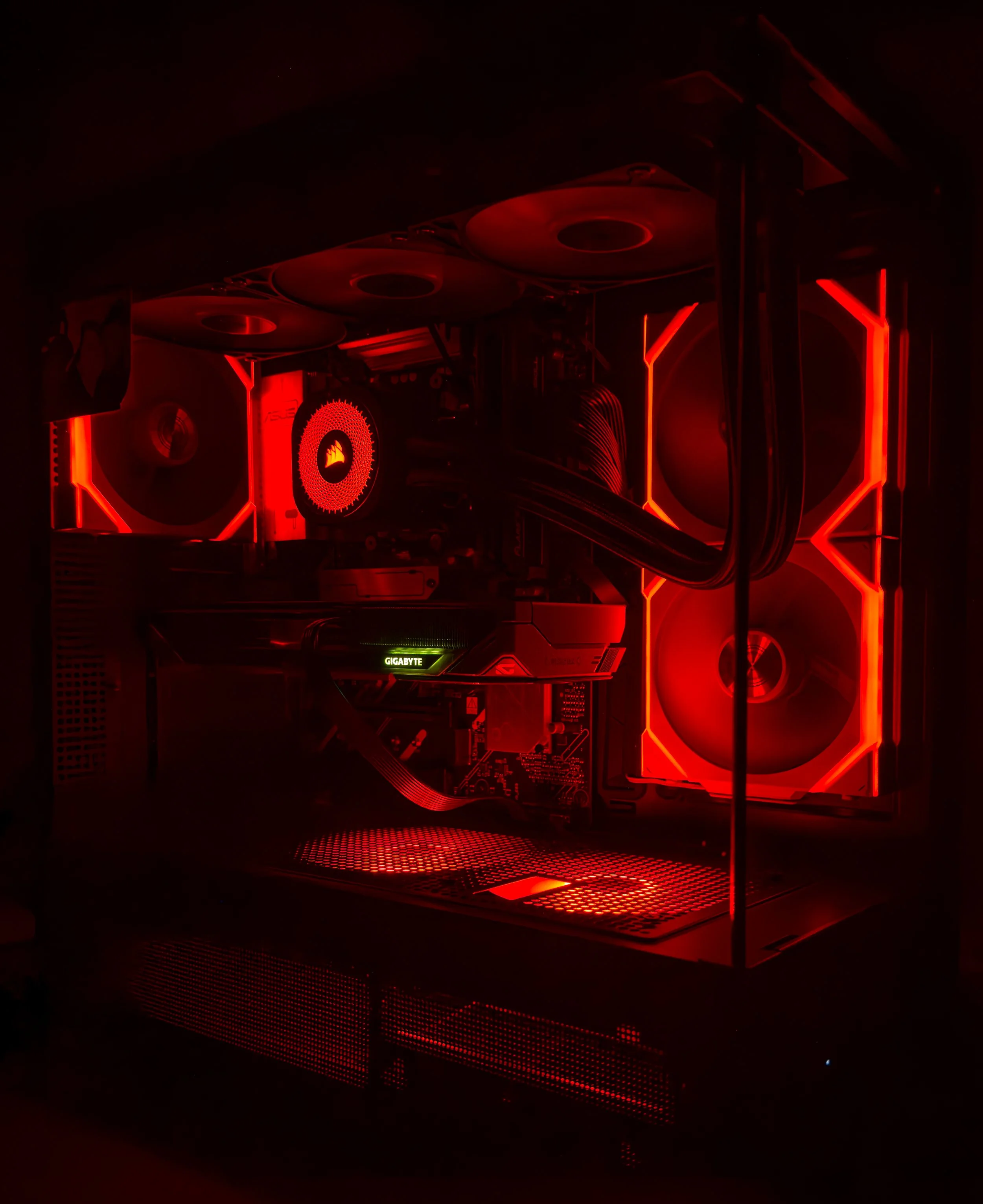 Inside a computer with red LED lighting, showing the motherboard, cooling fans, and other components.