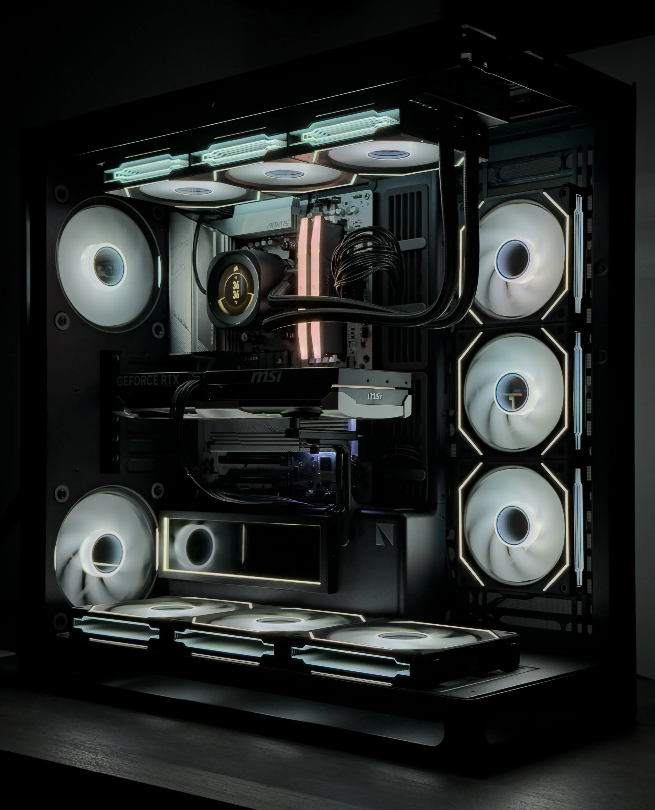 Inside view of a custom gaming computer showing illuminated cooling fans, a liquid cooling system, and a graphics card with LED lighting.