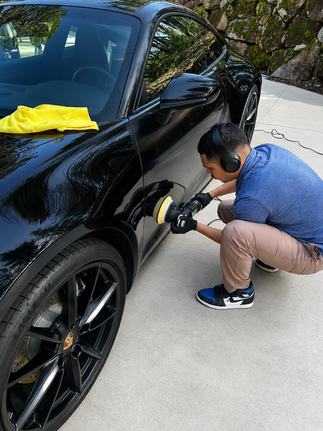 J's Mobile Detailing technician hand-polishing a vehicle in a Roseville, CA driveway.