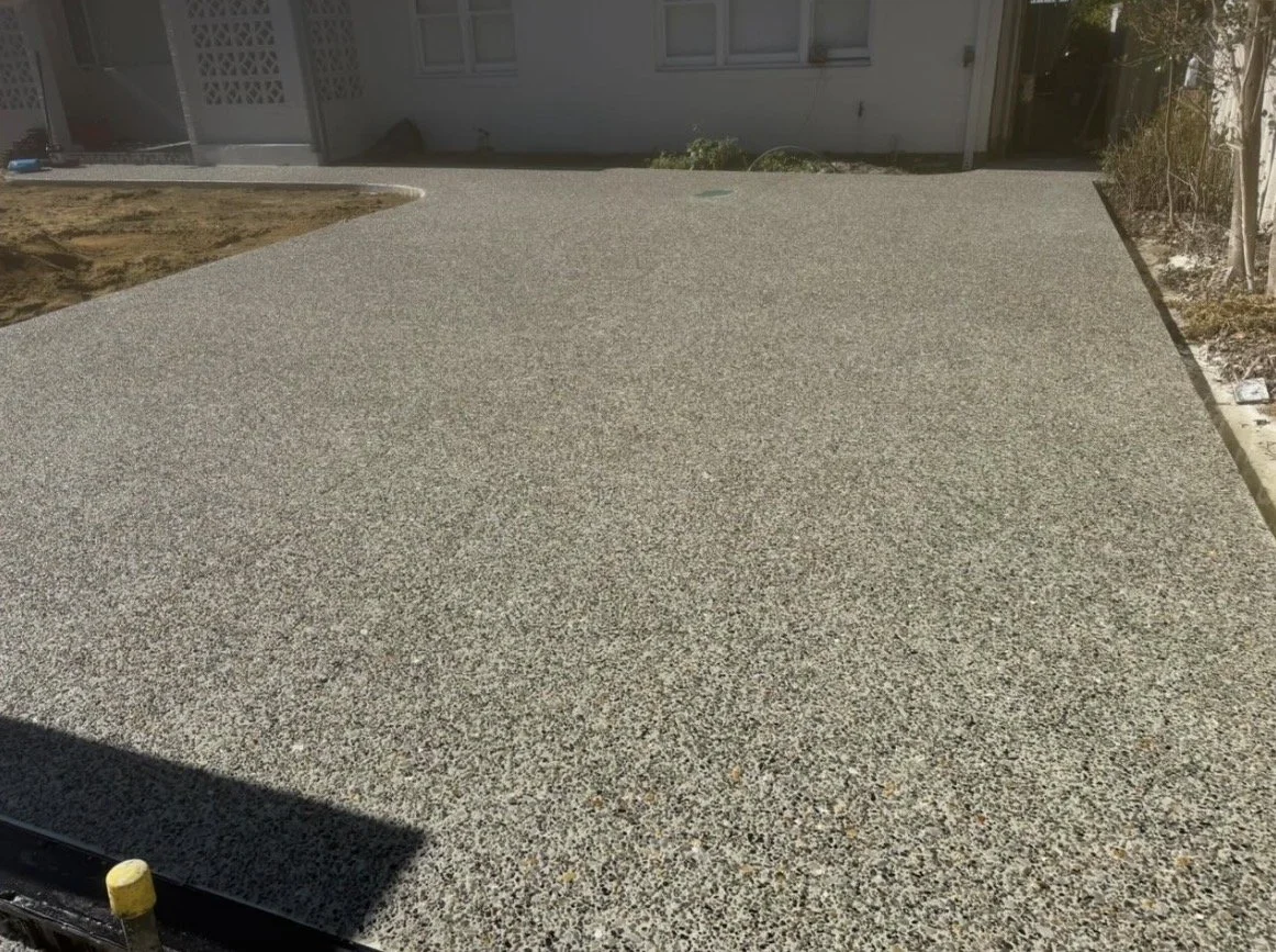 Freshly poured concrete slab in a backyard.