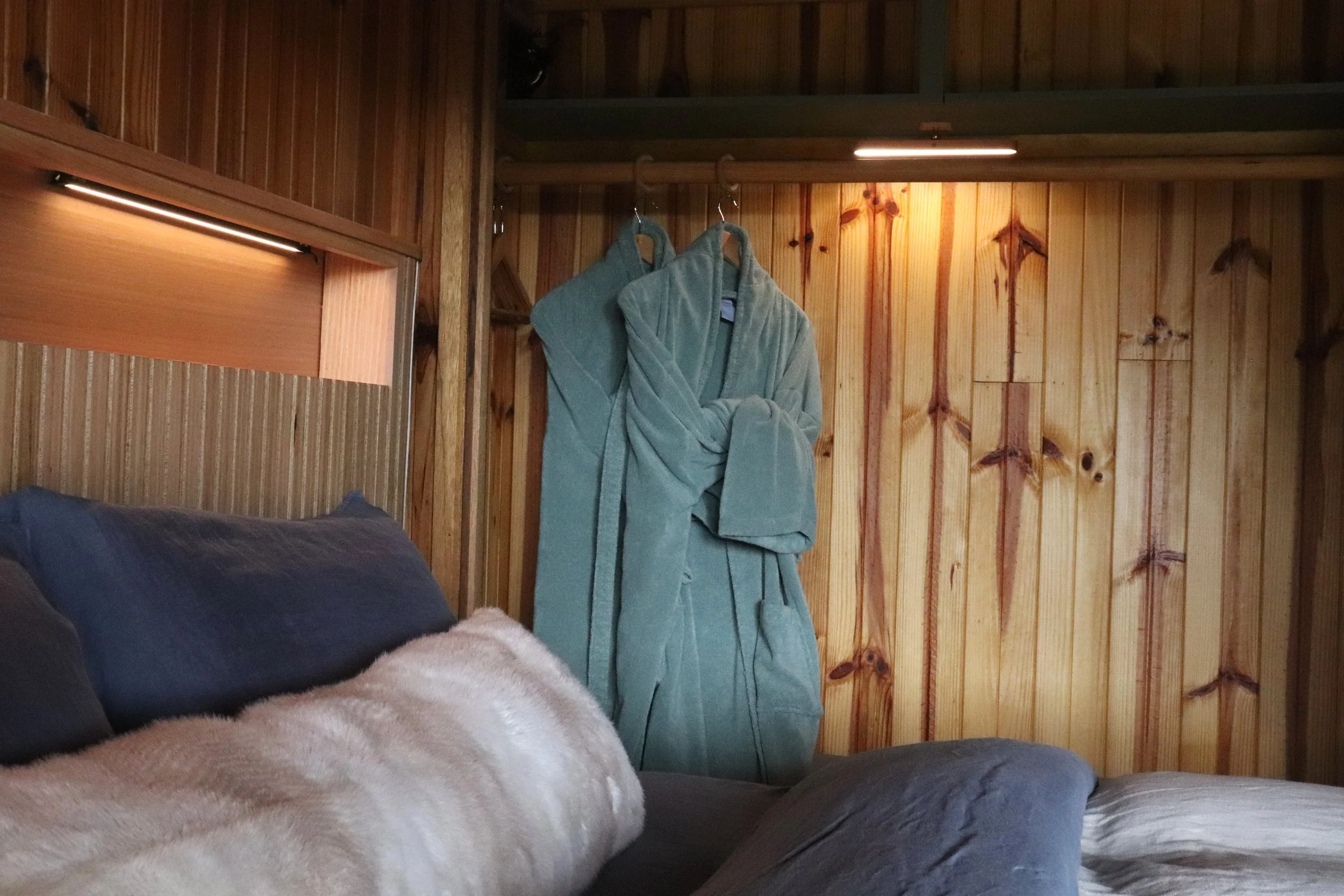 Bedroom with robes at Howqua Hideaway, a 1970s cedarwood cabin in Howqua Valley
