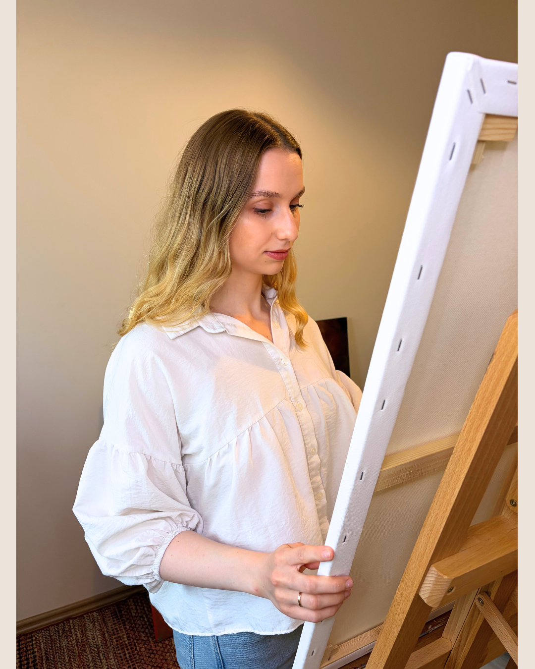 Lea Dékány holding a canvas in her Budapest art studio