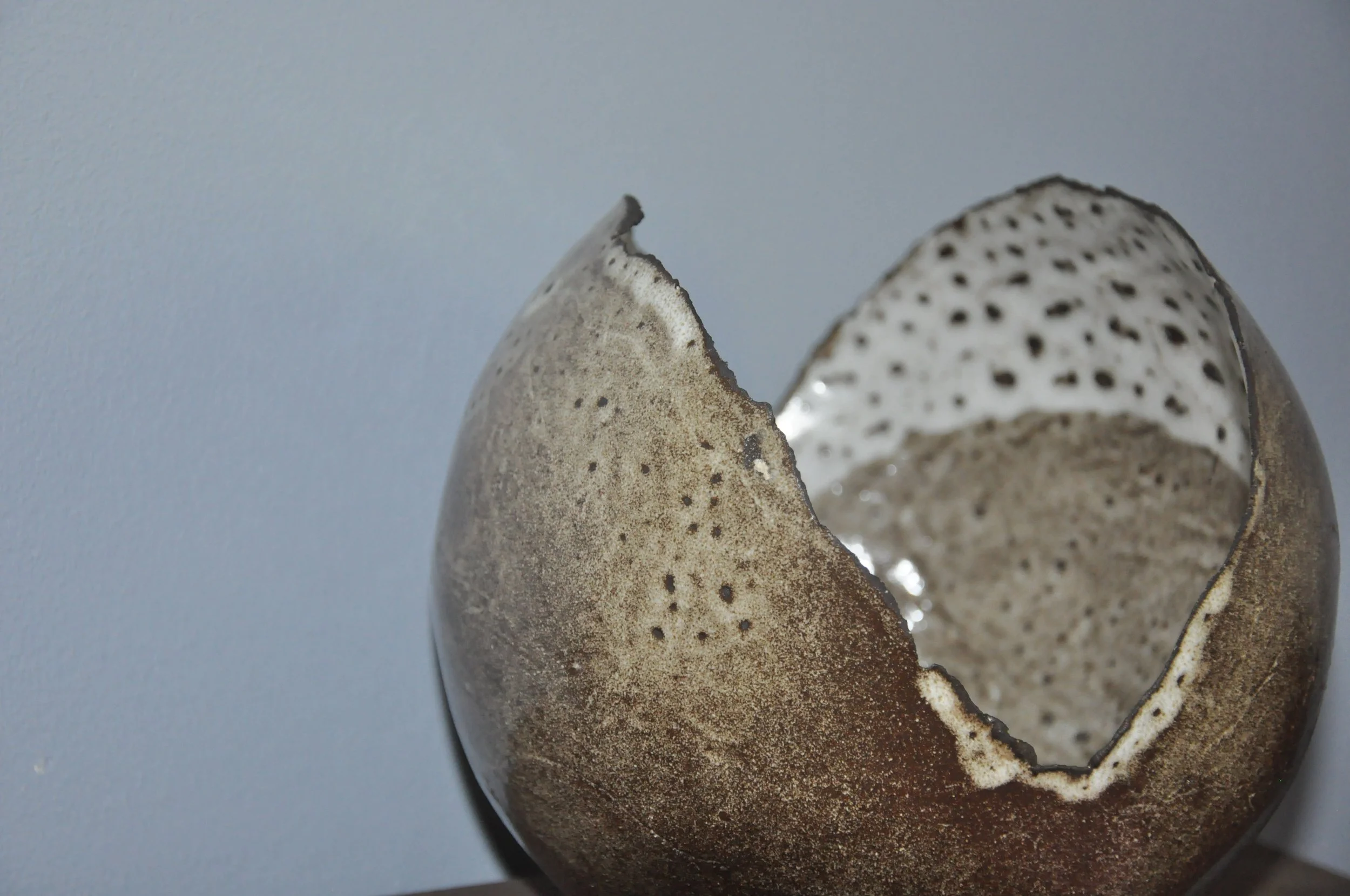 Une lampe en forme de sphère ouverte avec un intérieur blanc et noir.