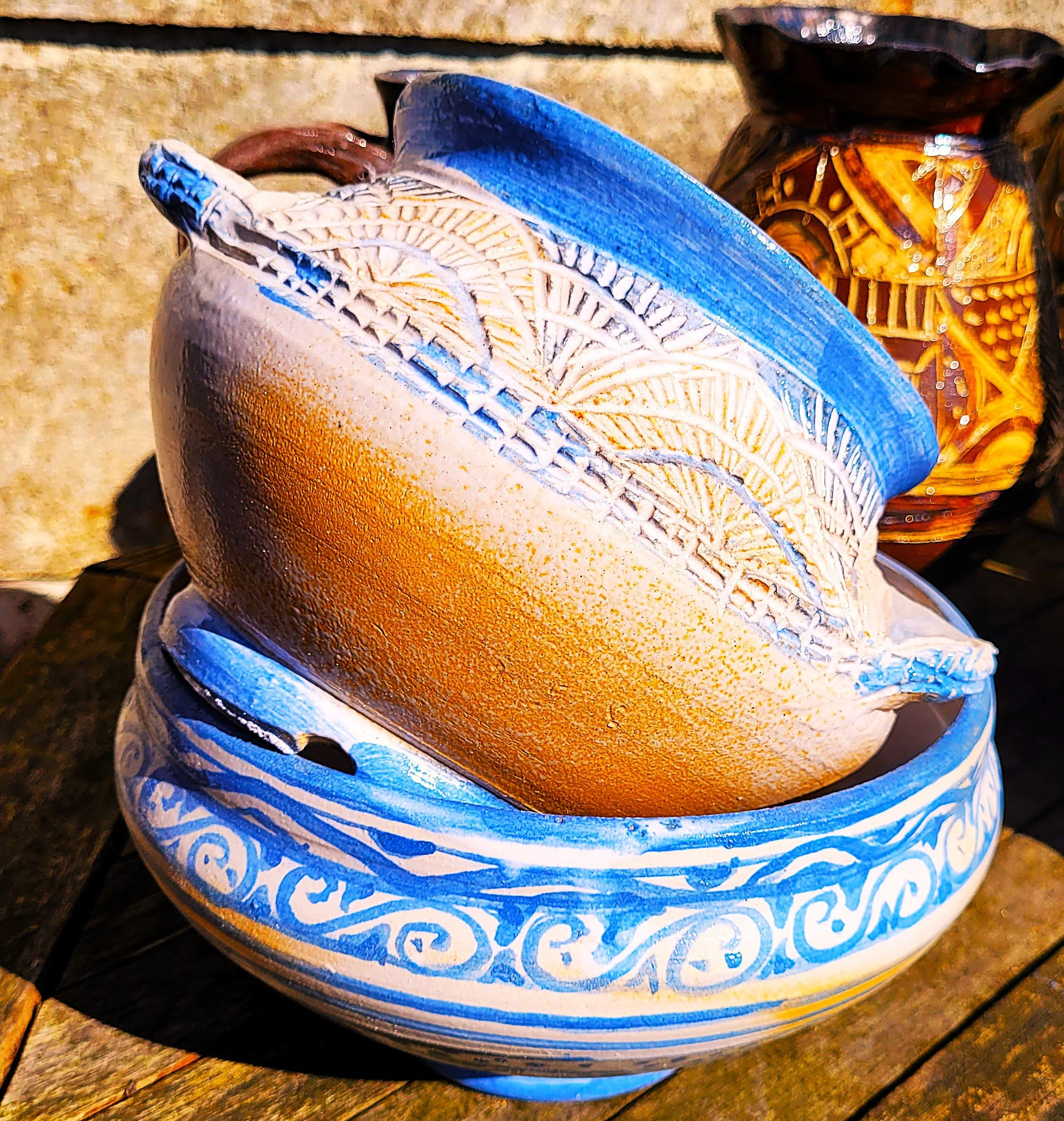 Dikke keramische pot met blauwe en witte decoraties, op een houten ondergrond.