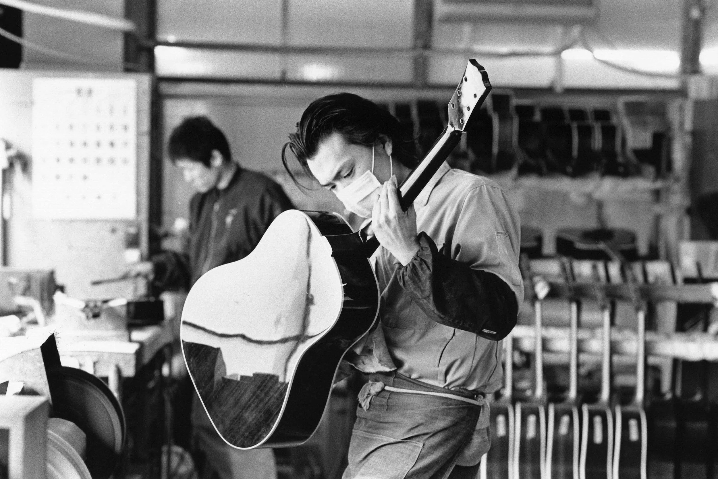 Un artisan K Yairi travaille sur le vernis d'une guitare Yairi dans les ateliers au Japon. 