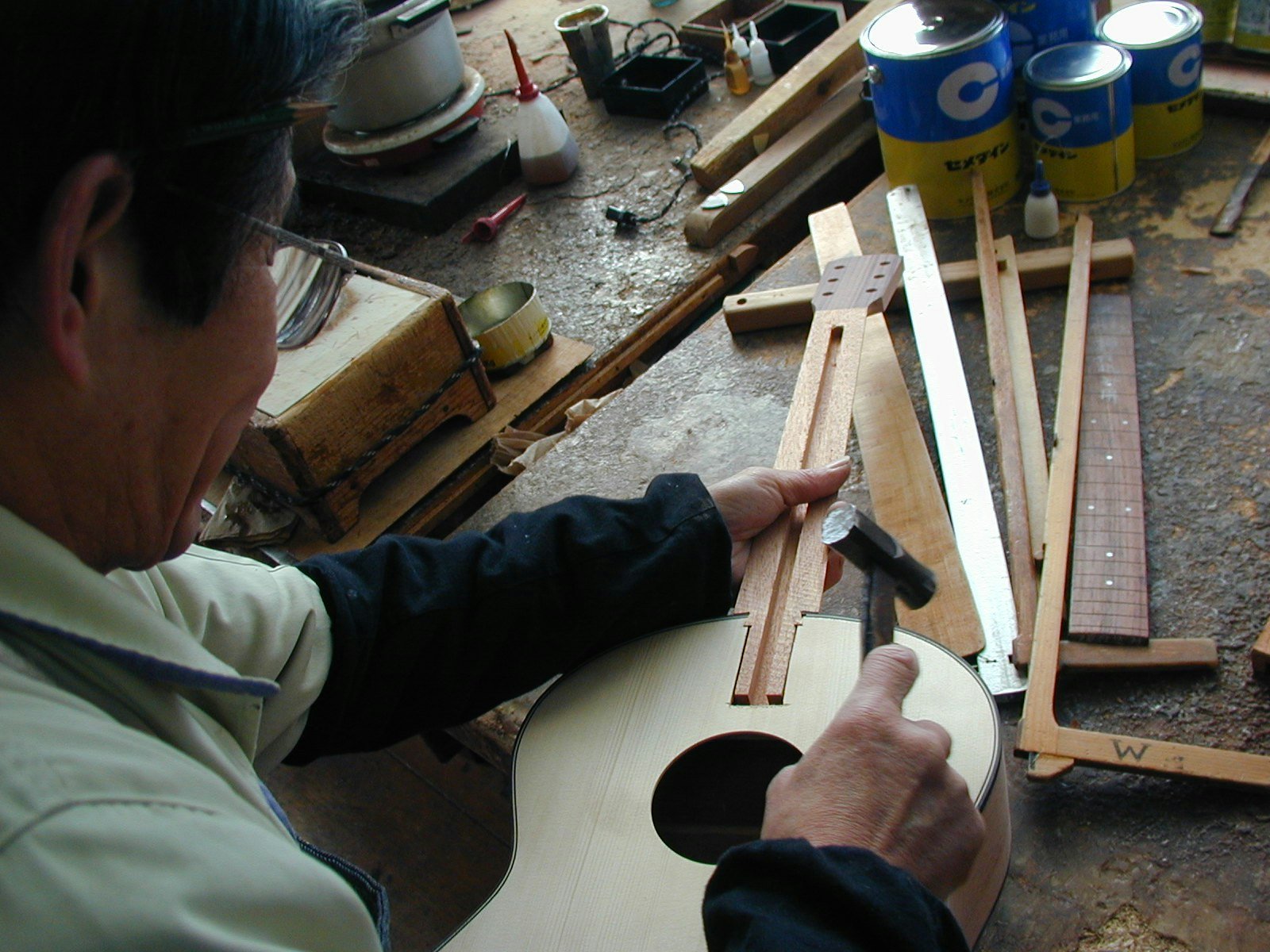 Un artisan K Yairi travaille sur l'assemblage du manche en queue d’aronde pour une guitare acoustique