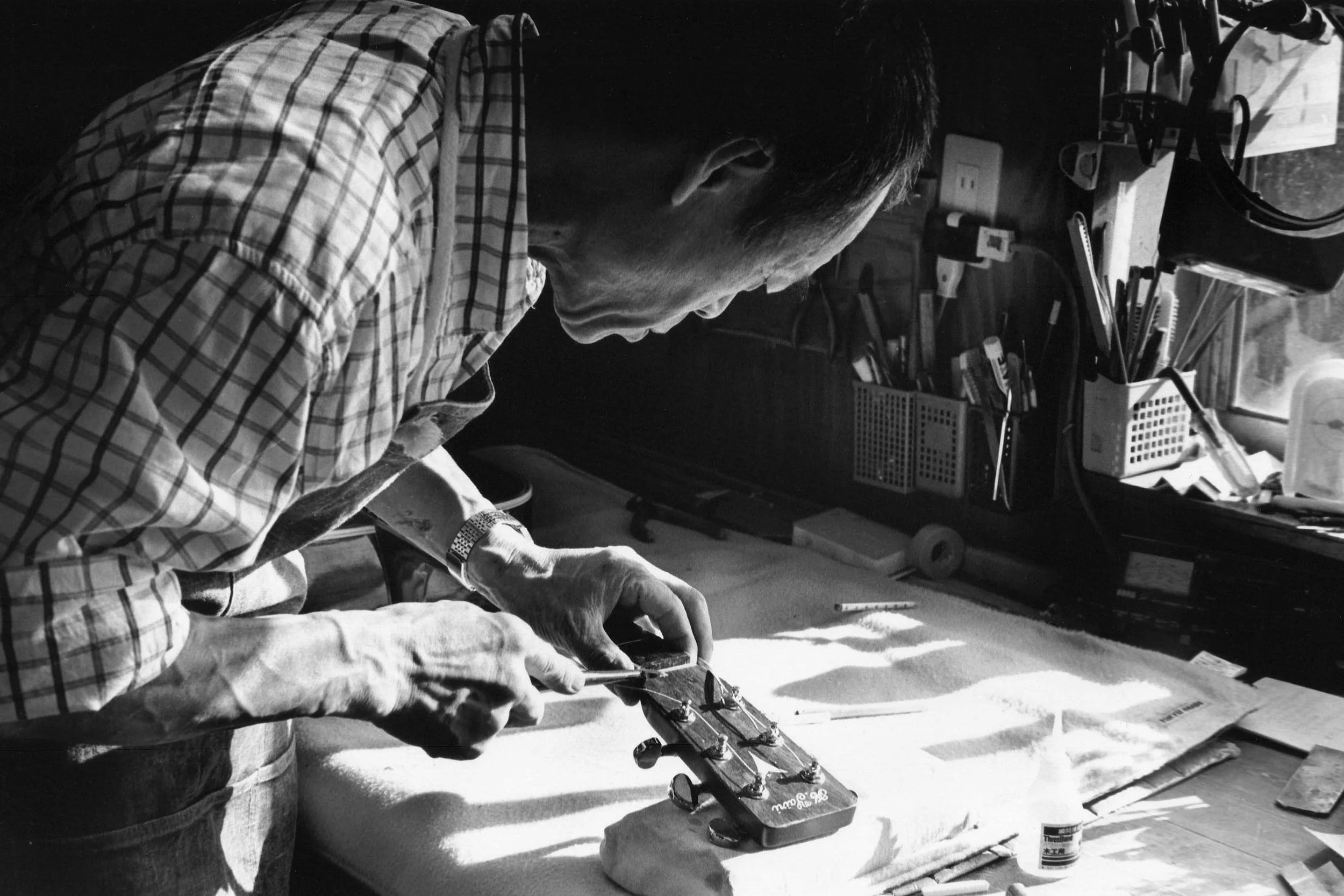 Un artisan Japonais travaille sur le manche d'une guitare dans les ateliers K Yairi