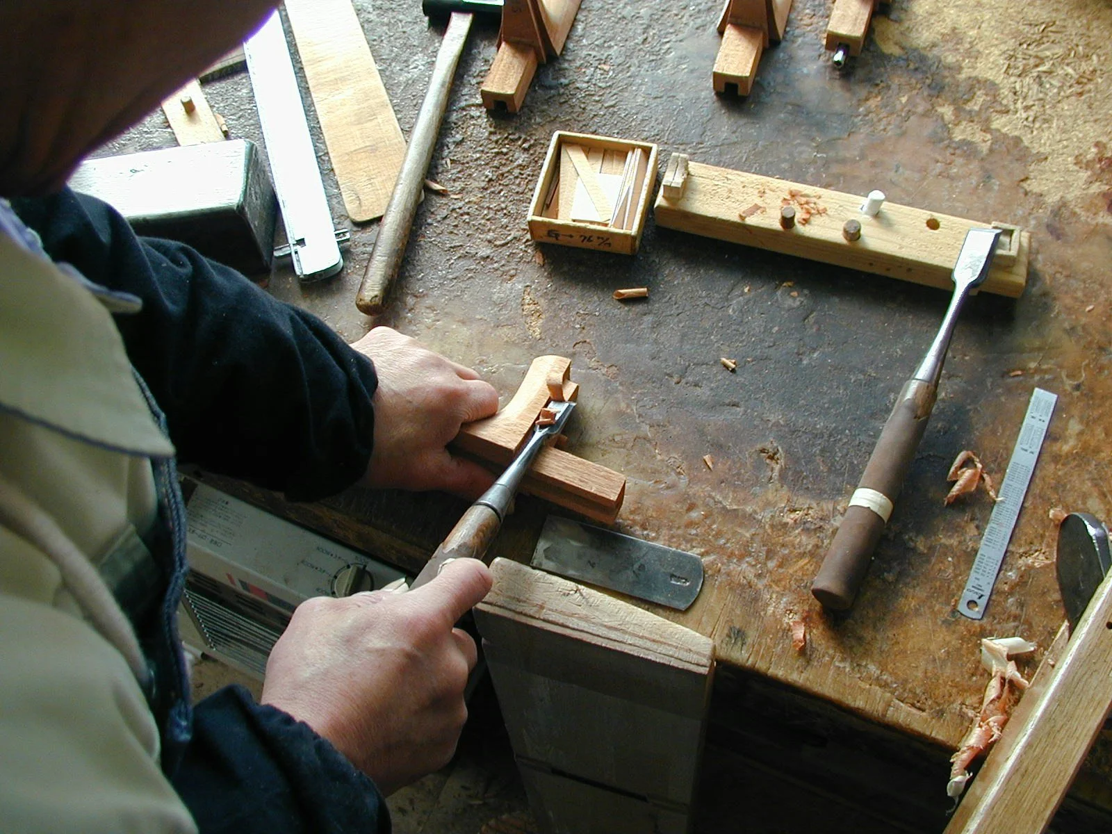 Un artisan K Yairi travaille sur l'assemblage du manche en queue d’aronde pour une guitare acoustique
