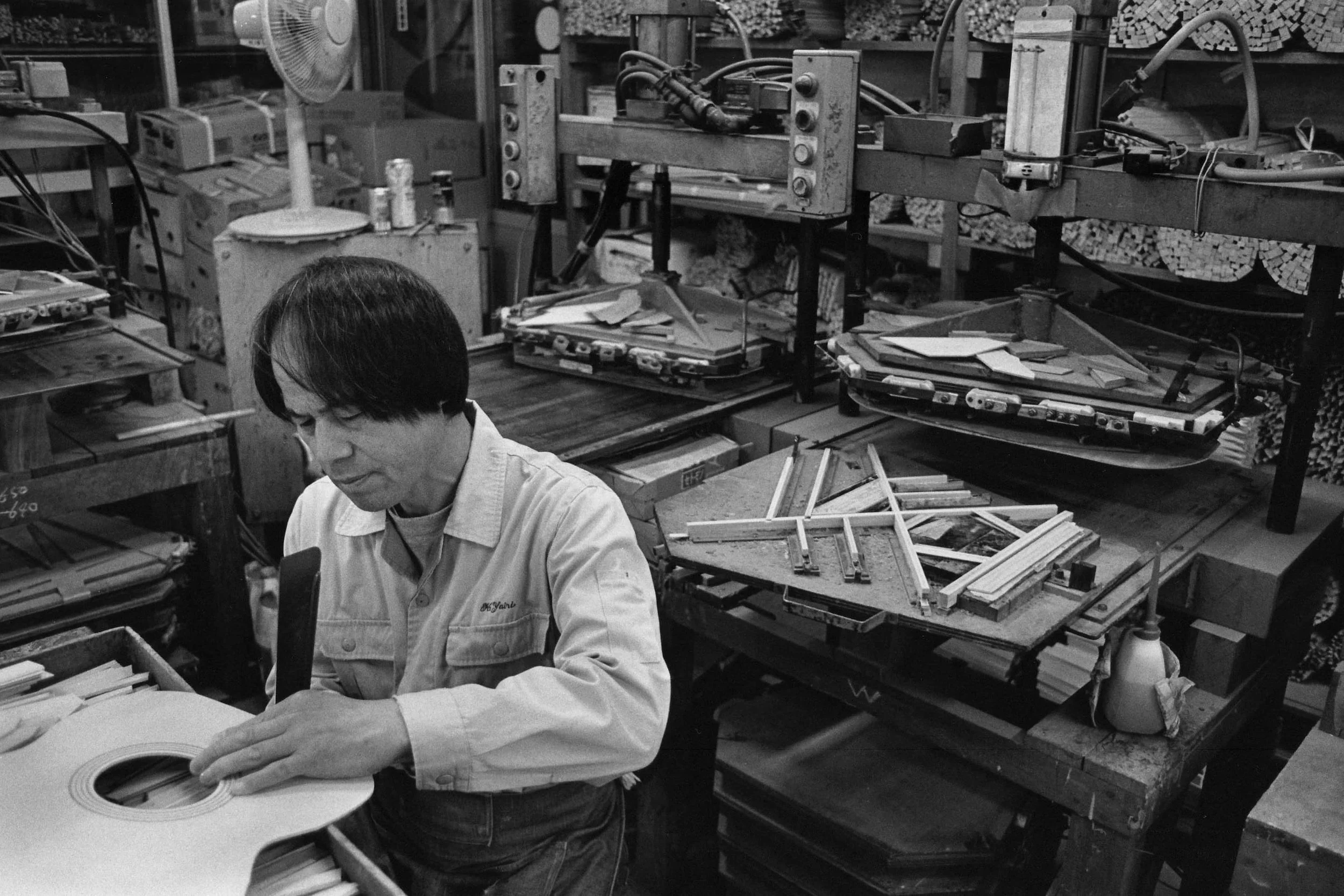 Un artisan K Yairi travaille le bois pour la création d'une guitare acoustique