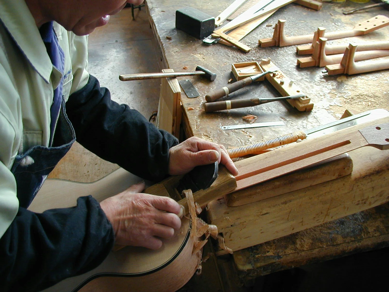 Un artisan K Yairi travaille sur l'assemblage du manche en queue d’aronde pour une guitare acoustique
