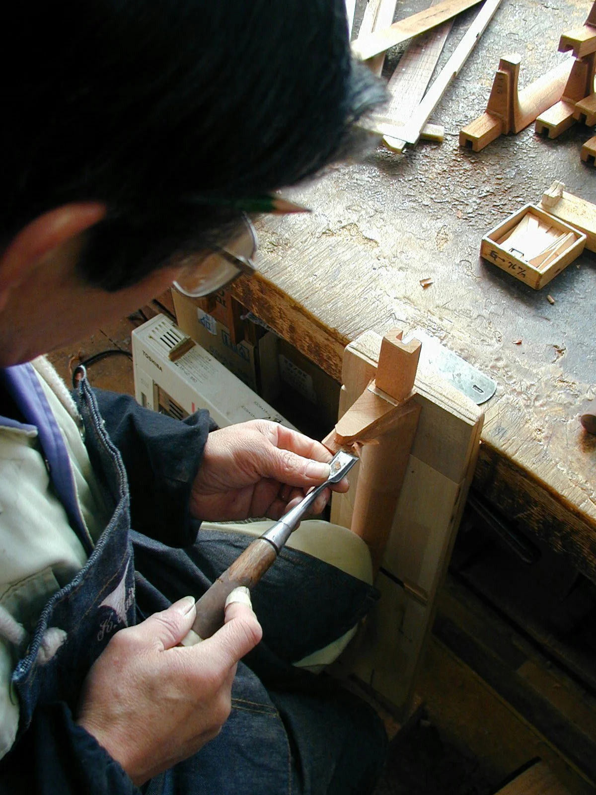 Un artisan K Yairi travaille sur l'assemblage du manche en queue d’aronde pour une guitare acoustique