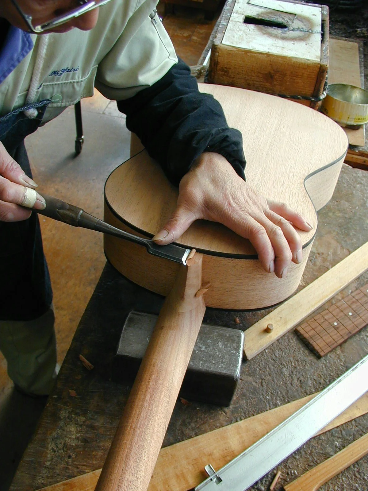 Un artisan K Yairi travaille sur l'assemblage du manche en queue d’aronde pour une guitare acoustique