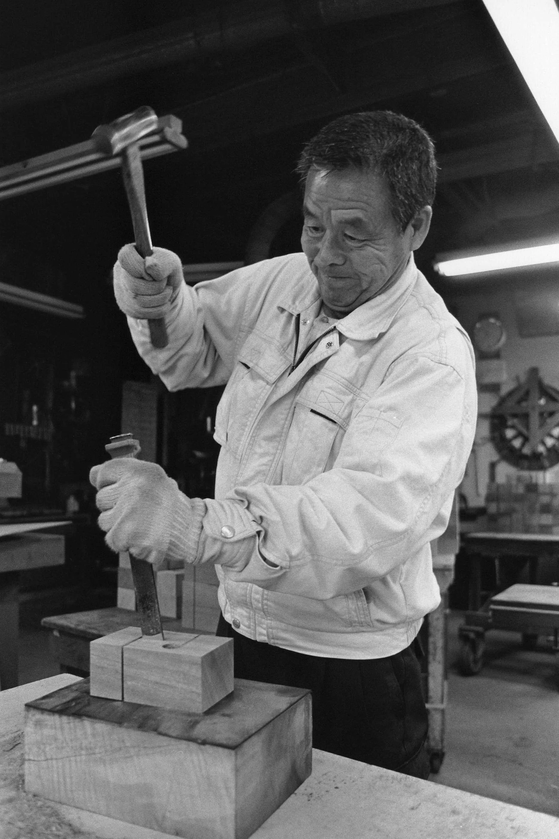 Un artisan Japonais travaille le bois pour la fabrication d'une guitare acoustique dans les ateliers K Yairi