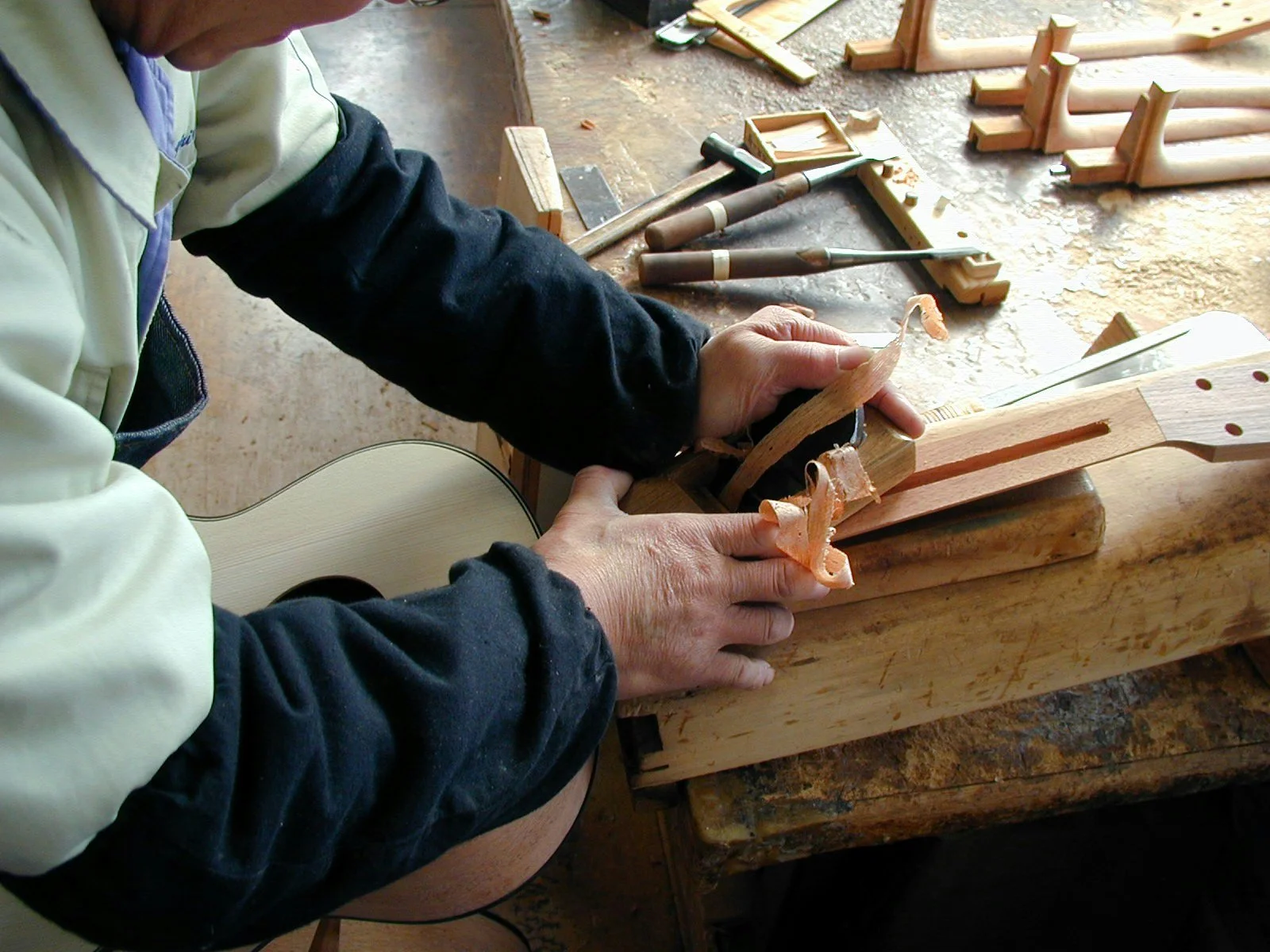 Un artisan K Yairi travaille sur l'assemblage du manche en queue d’aronde pour une guitare acoustique