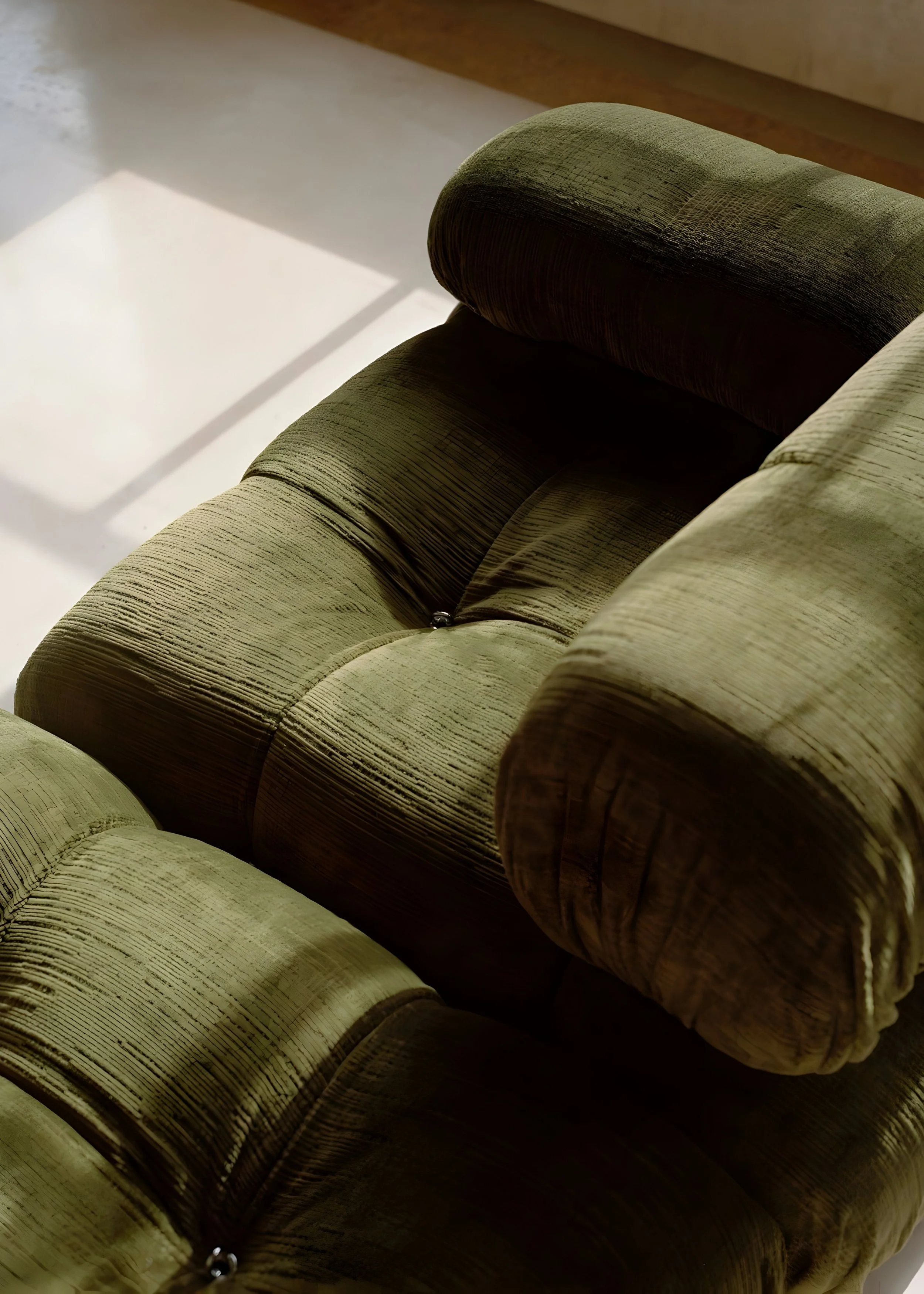 Close-up of an olive green sofa.