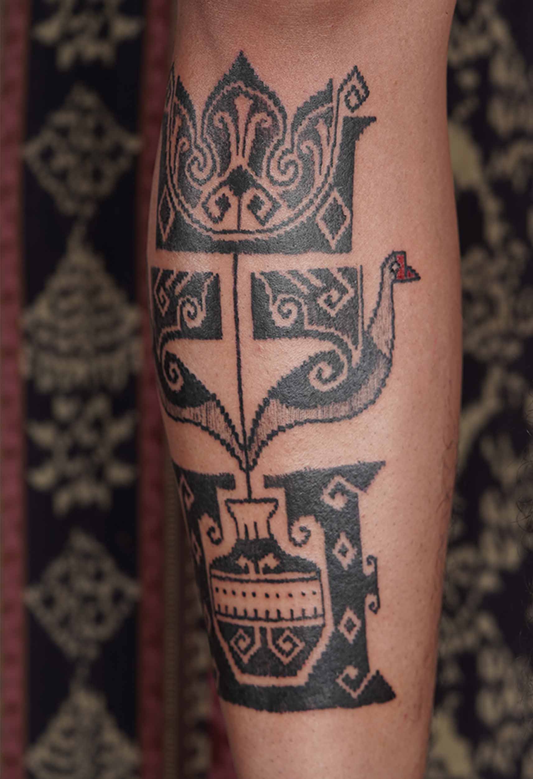 flower in a pot tattoo with black work style on lower front leg placement