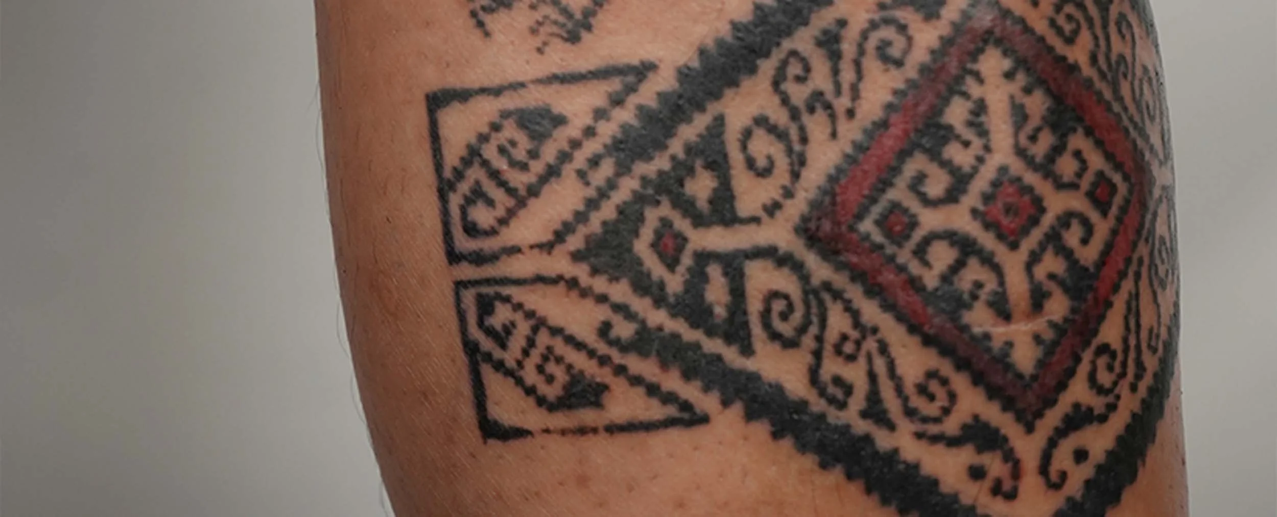 Bold ornament tattoo on man shin inspired by traditional pattern of indonesia in bali