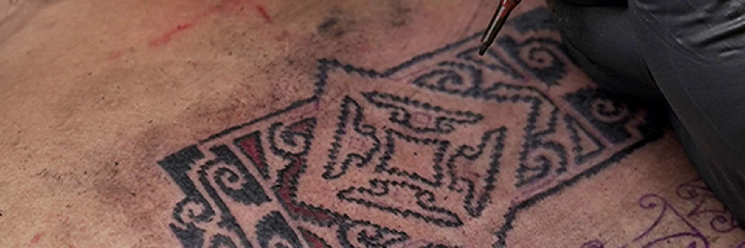 ornamental flower tattoo with red color by bali based tattoo artist