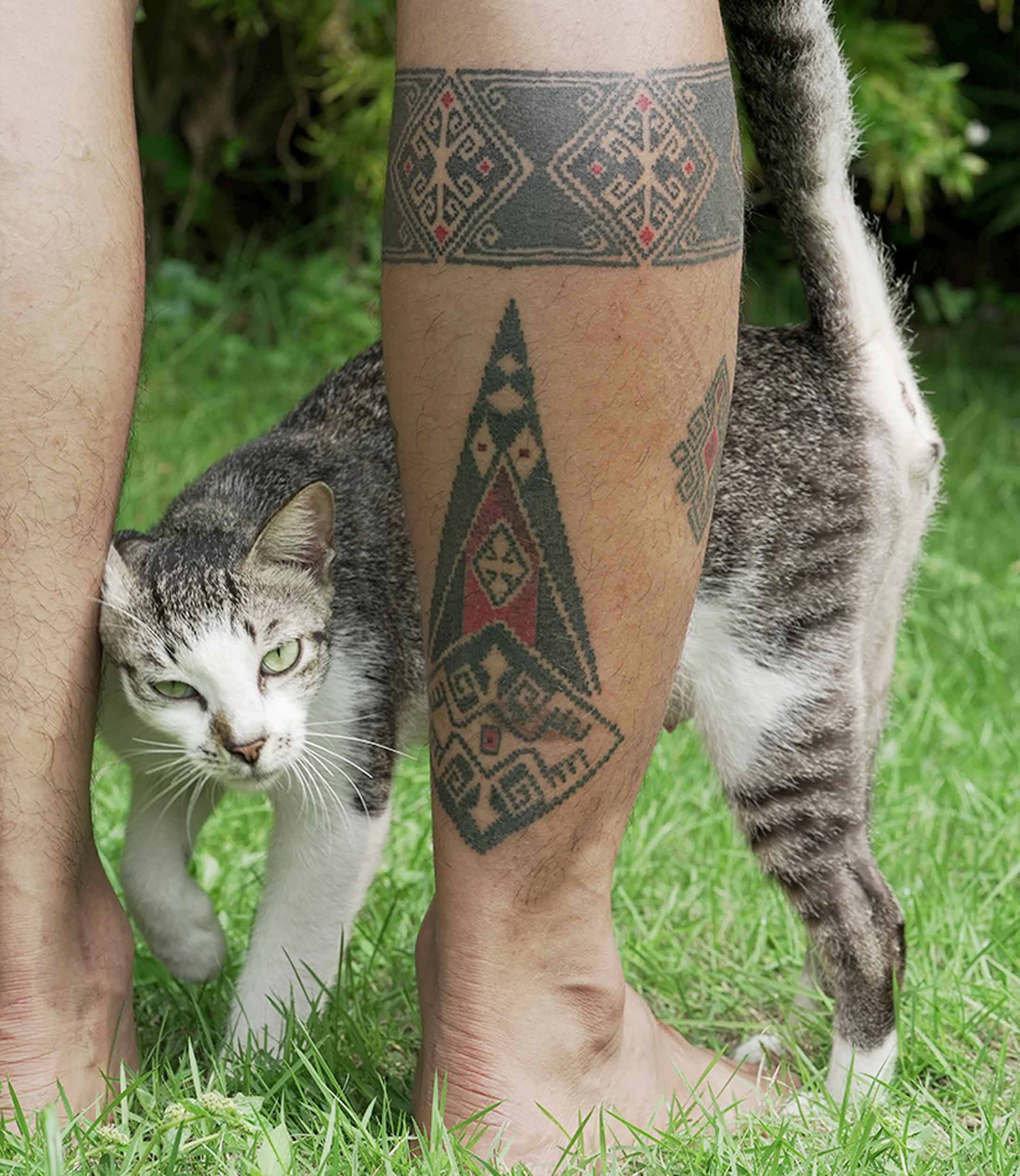 ornamental black work bali on man calf tattoo inspired by batik and tenun motif