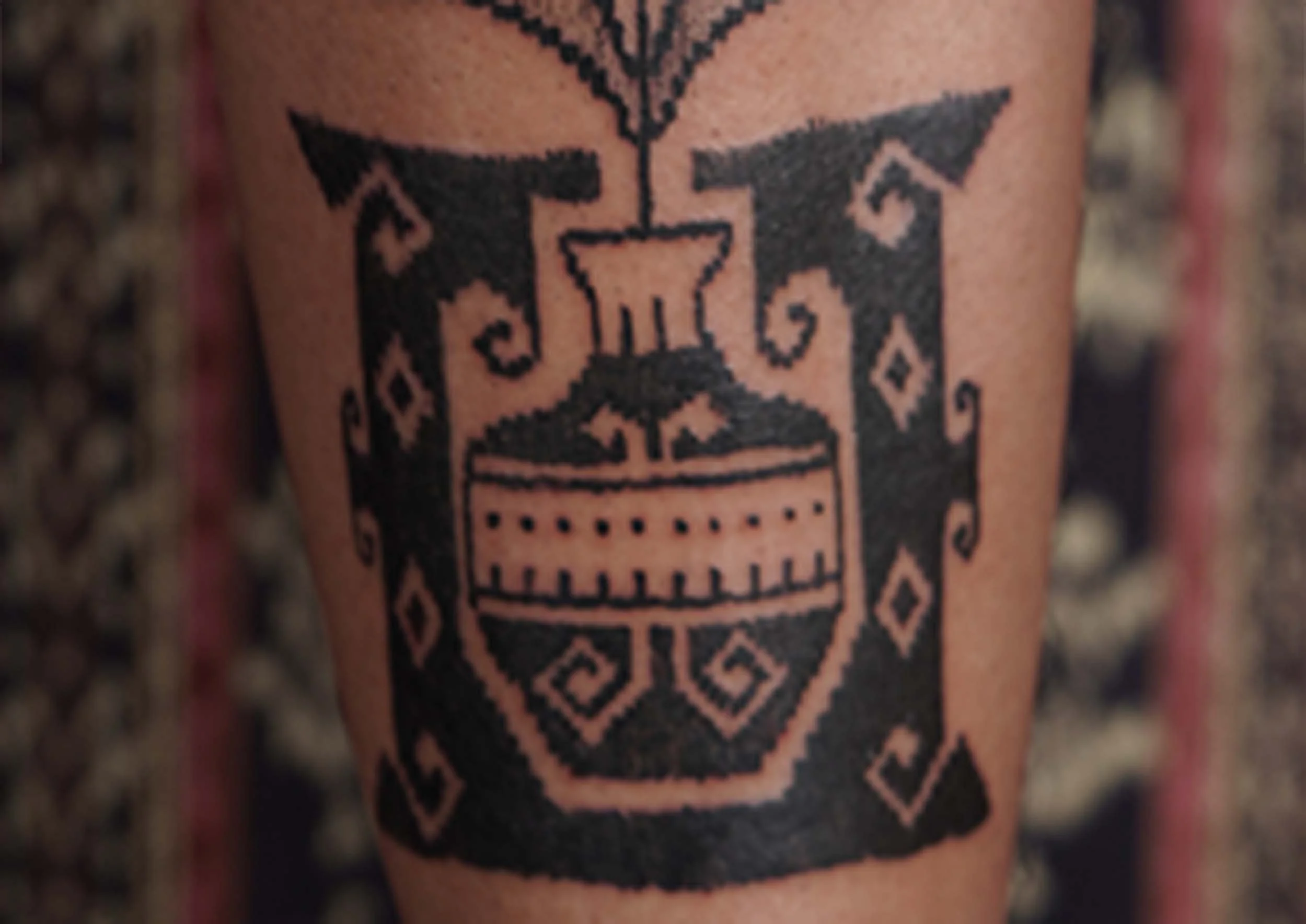 ornamental pot tattoo with black work ornamental style on shin bone