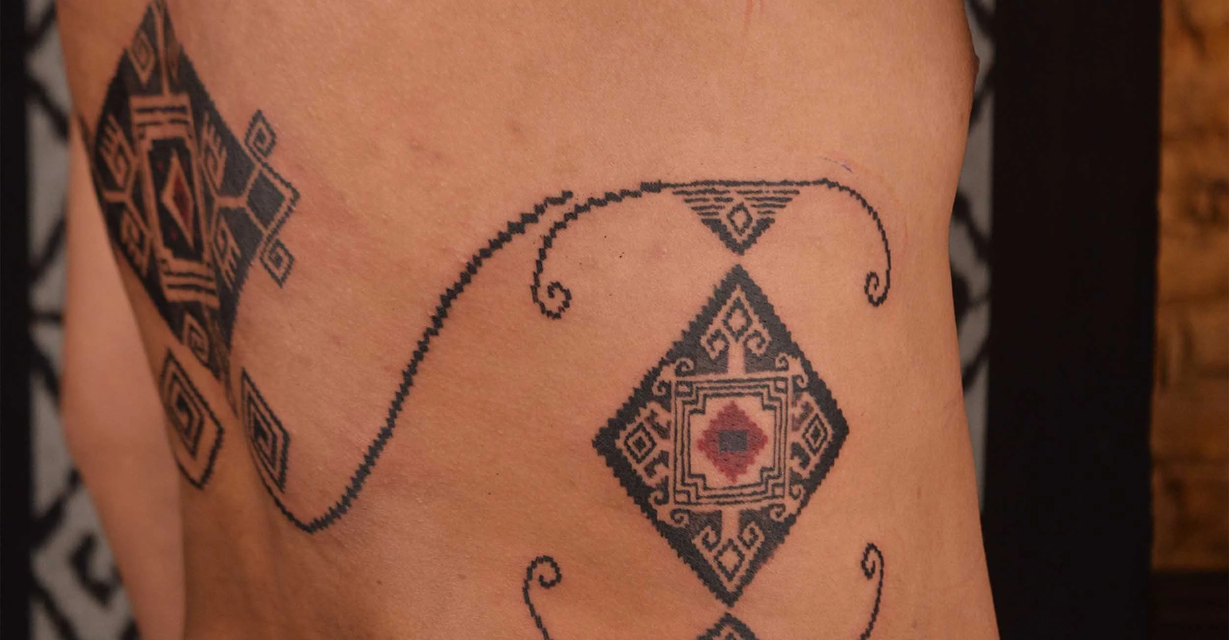 ornamental ribs and lower back tattoo by bali based tattoo artist