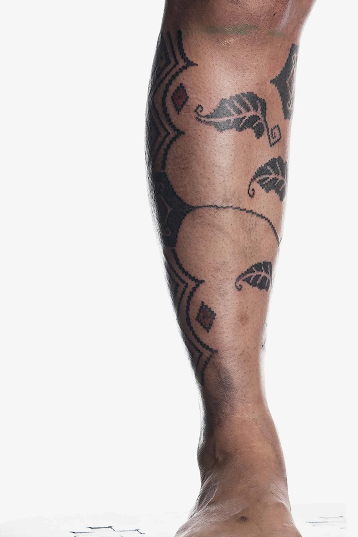 delicate black work ornamental tattoo on man leg done in Bali studio