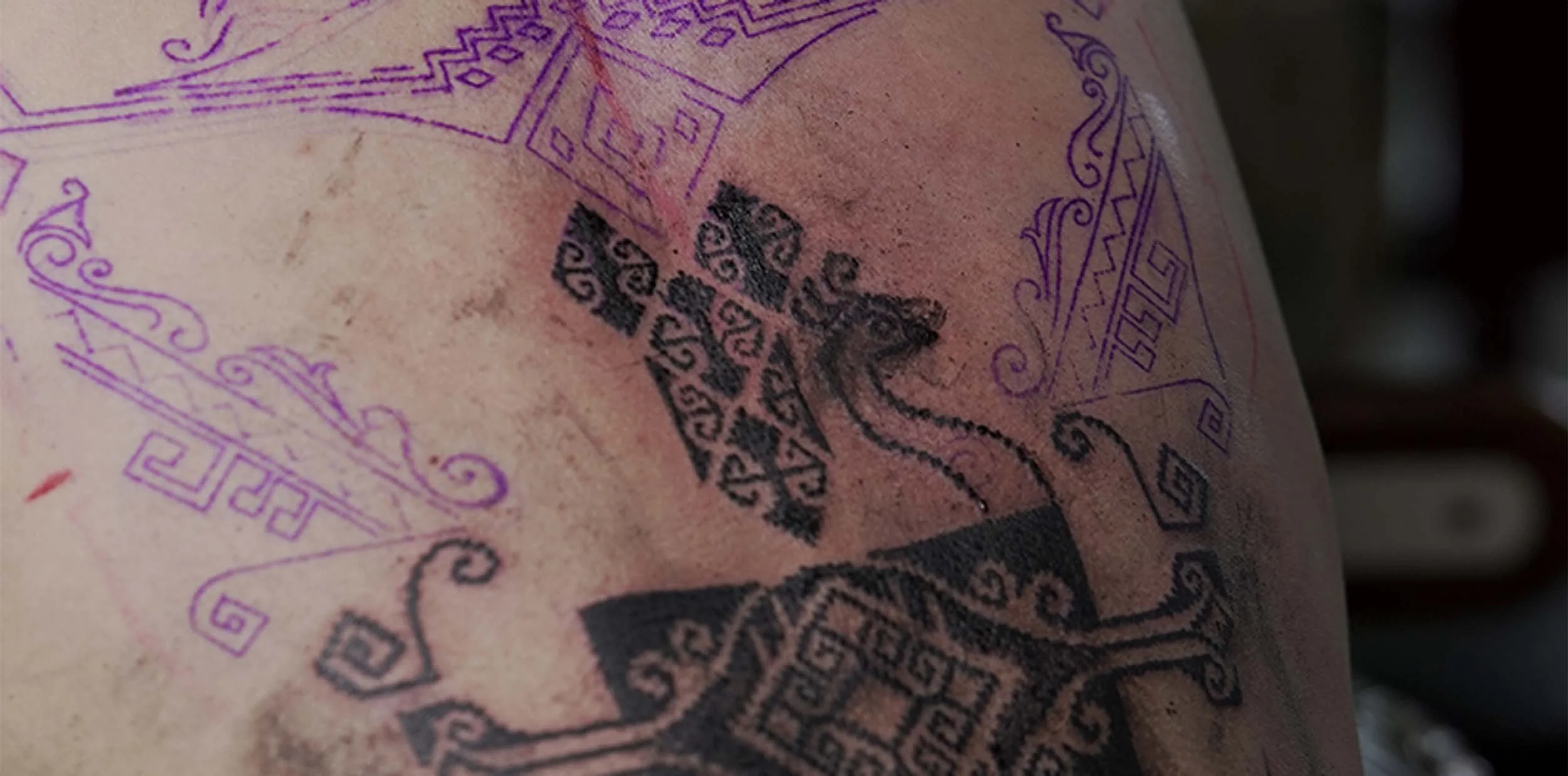 bold black work back tattoo in ornamental style with delicate detail