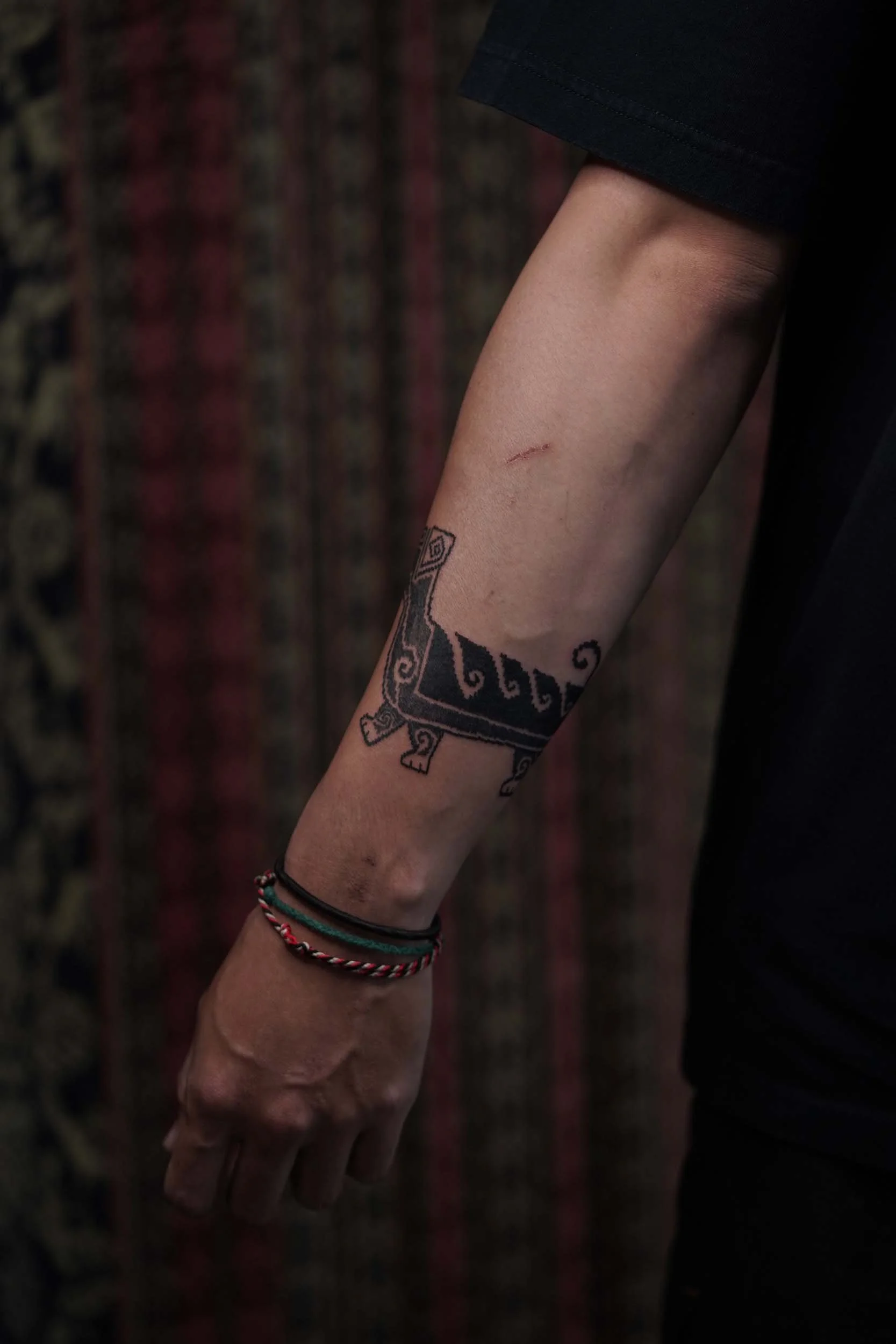 ornamental dog tattoo above the wirst