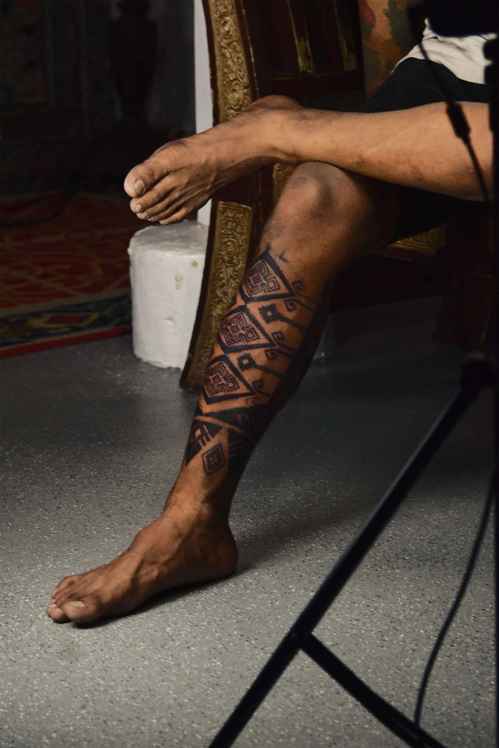 man chilling in near canggu tattoo studio wfter getting a lower leg sleeves tattoo done by bali based tattoo artist