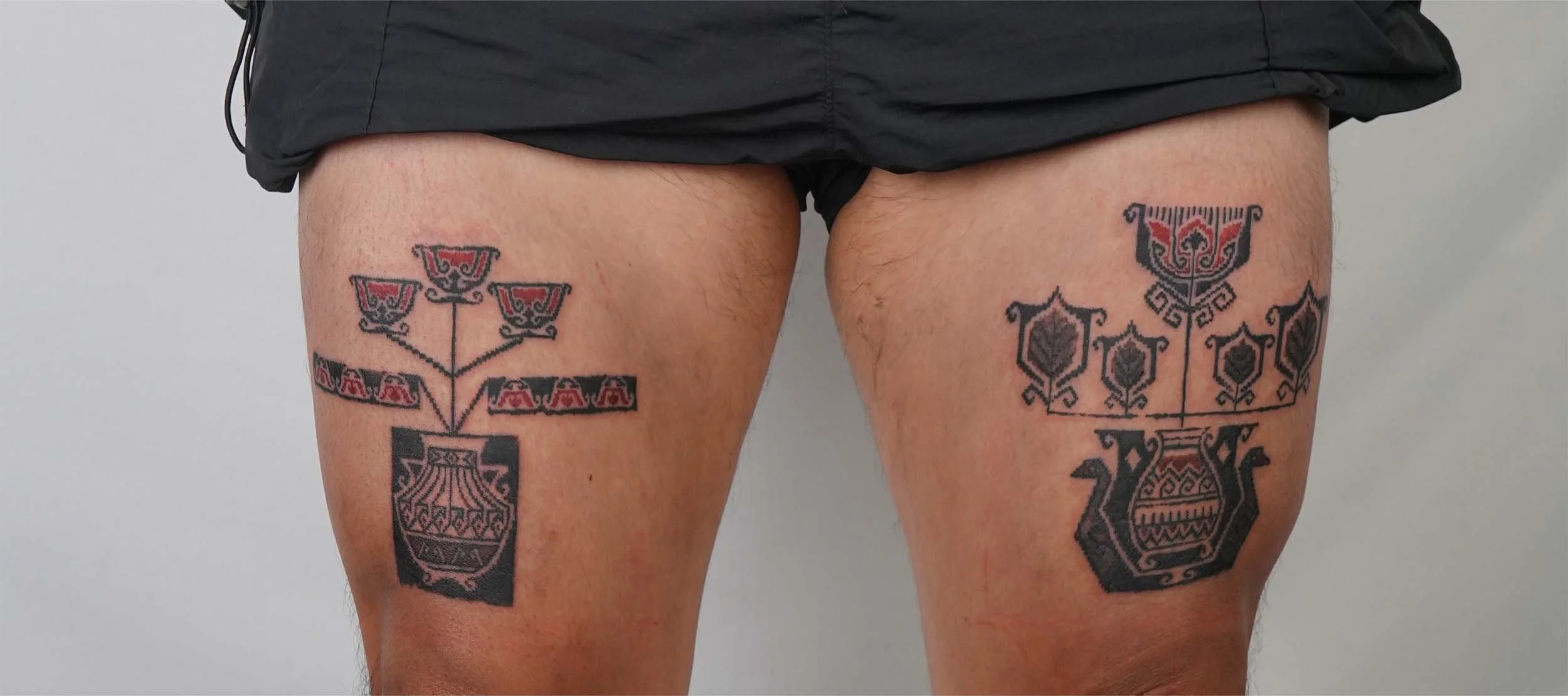 ornamental flower in vase tattoo on thigh