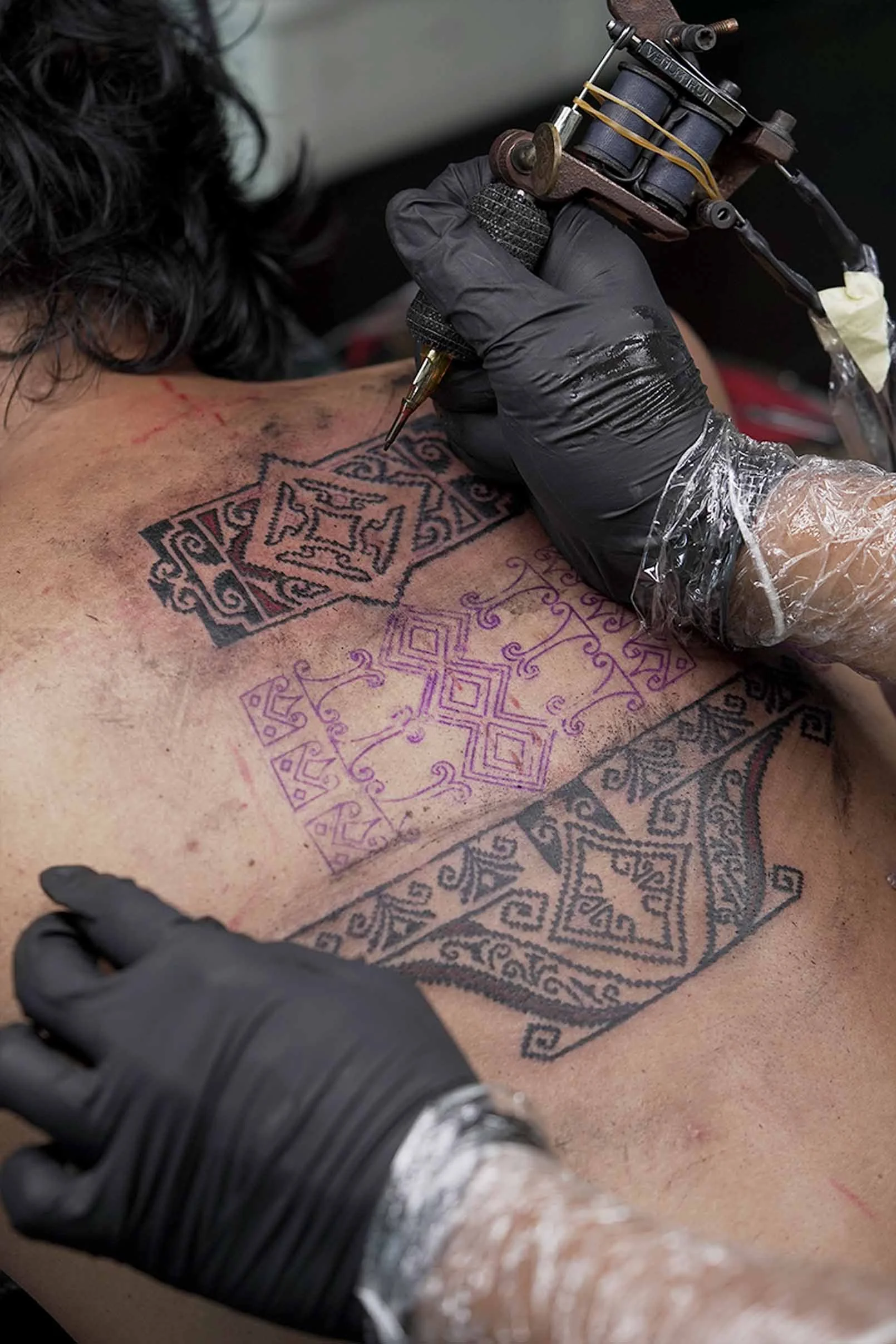 tenun tattoo on back in ornamental style by bali based tattoo artist