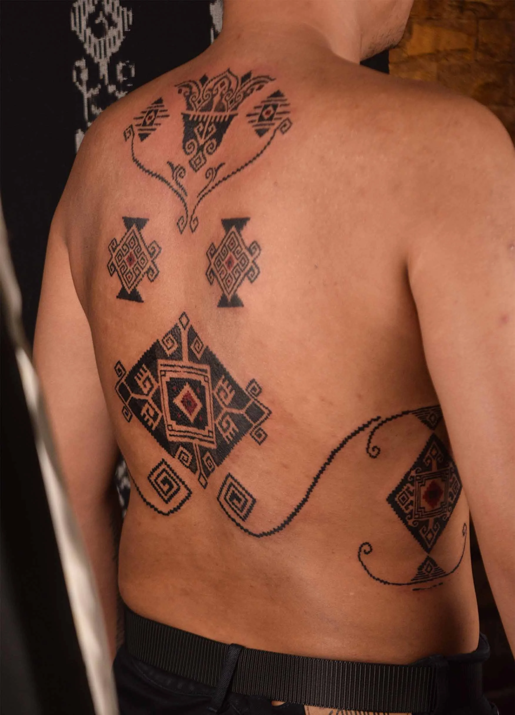 man back and ribs tattoo with ornament style with tenun motif