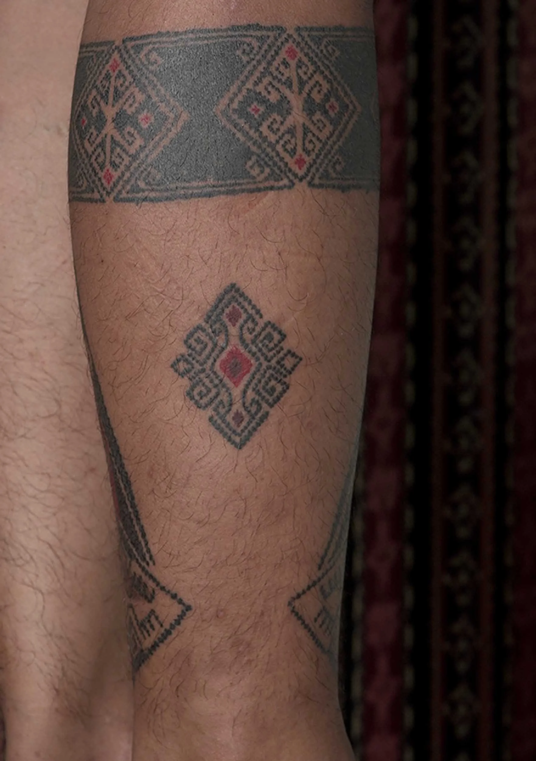 leg tattoo in ornamental style with red ascent in bali