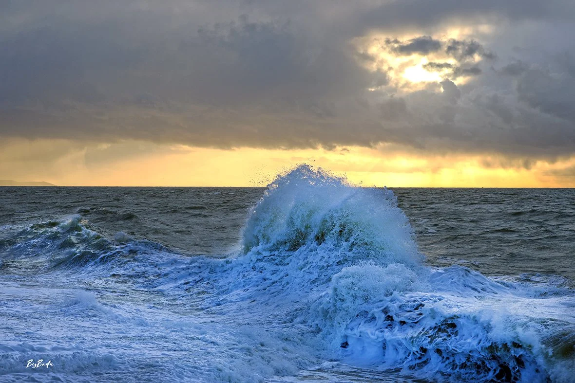 Belle photo — vague bleue explosive au coucher de soleil doré !
`La vague bleue explose. Le soleil brûle derrière. La Manche ne demande pas la permission.`