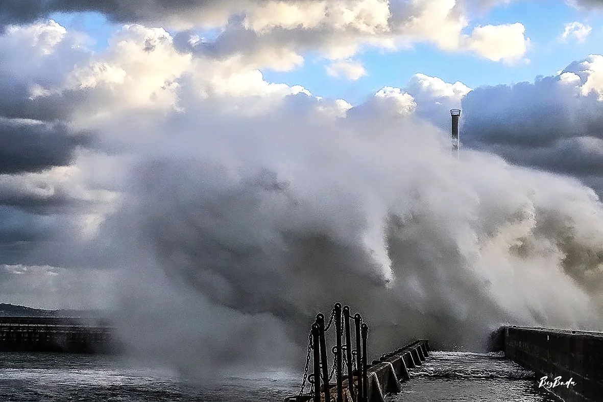 La vague explose. Le phare disparaît dans la brume blanche. Et pourtant, il tient.