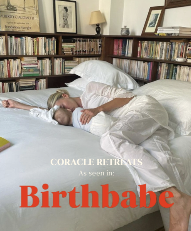 A woman lying on a bed, breastfeeding a baby, in a room with bookshelves and framed pictures on the wall