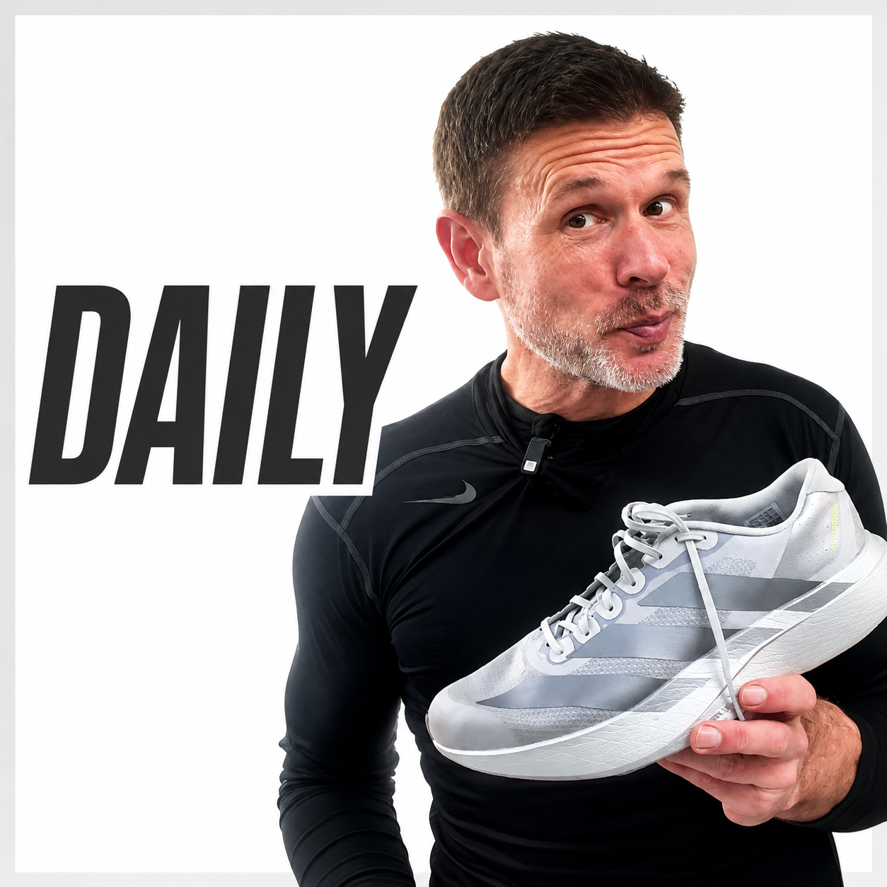 A man with short dark hair and a beard posing with a white athletic shoe, wearing a black athletic shirt, with the word "DAILY" in bold black letters on a white background.