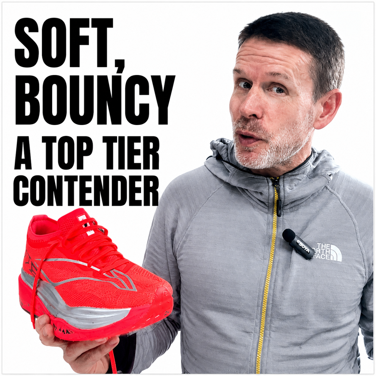 A man in a gray Nike jacket holding a red athletic shoe, with text that reads "Soft, Bouncy, A Top Tier Contender".
