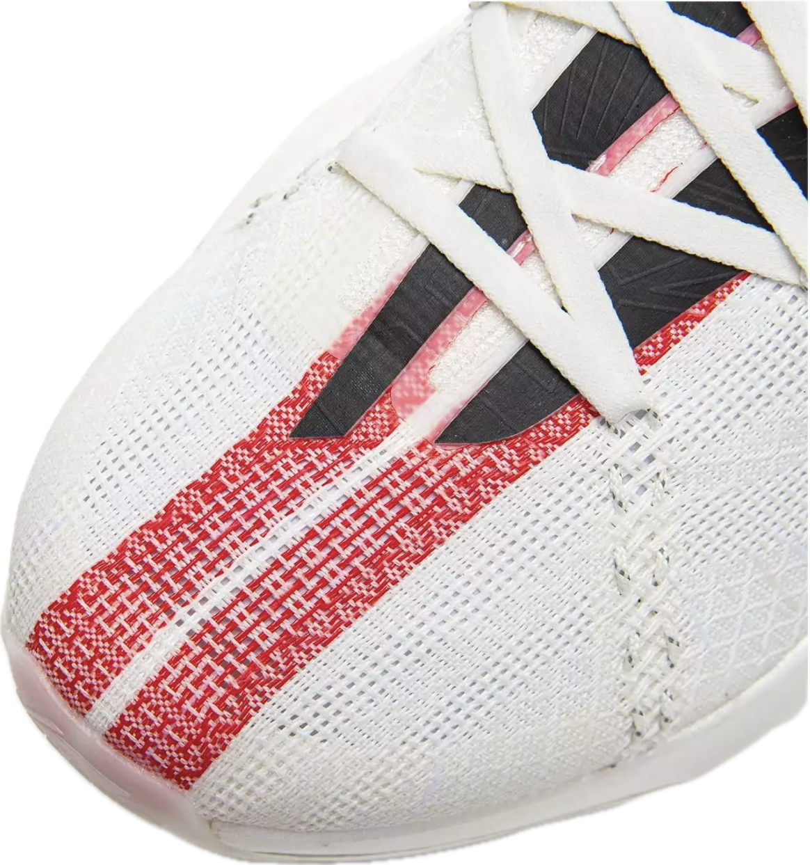 Close-up view of a white athletic shoe with black and red accents and white laces.
