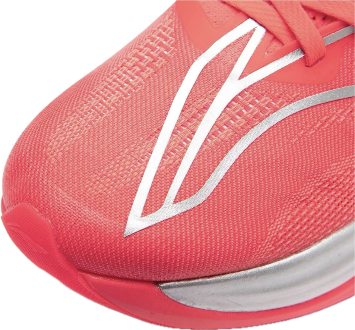 Close-up of a coral-colored athletic shoe with a white logo on the top and silver accents.
